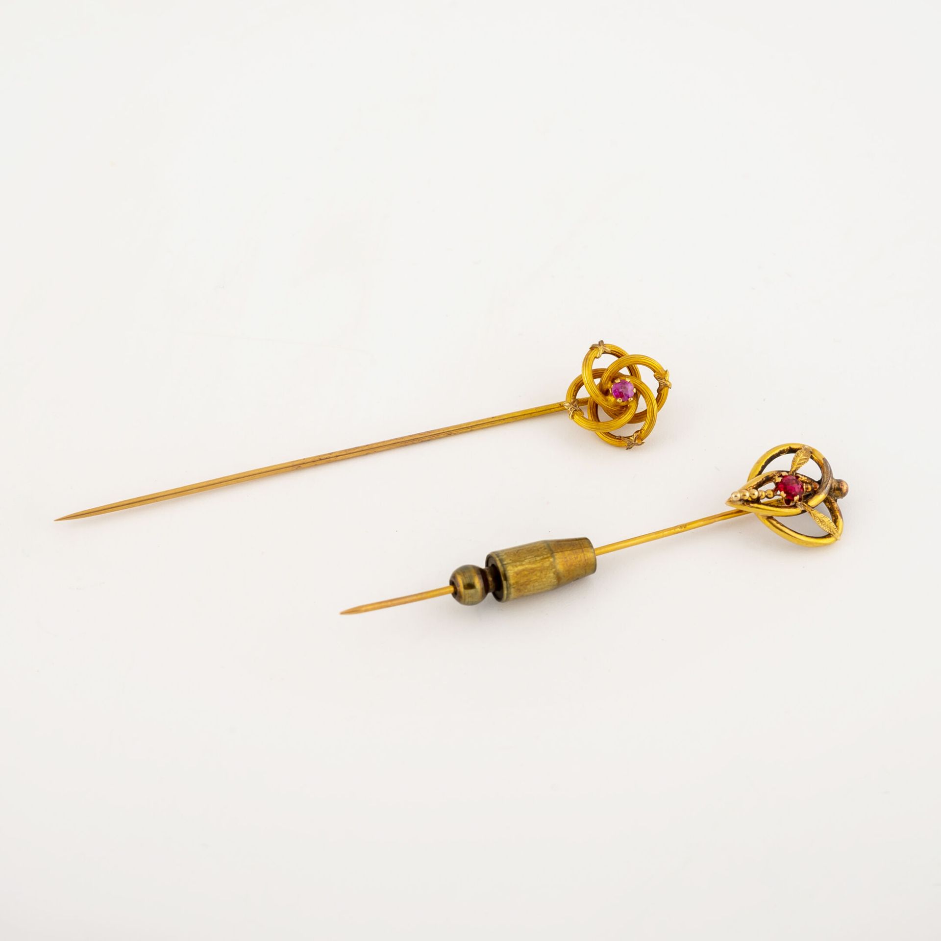 Null Two yellow gold (750) tie pins set with round faceted red glass in a claw s&hellip;
