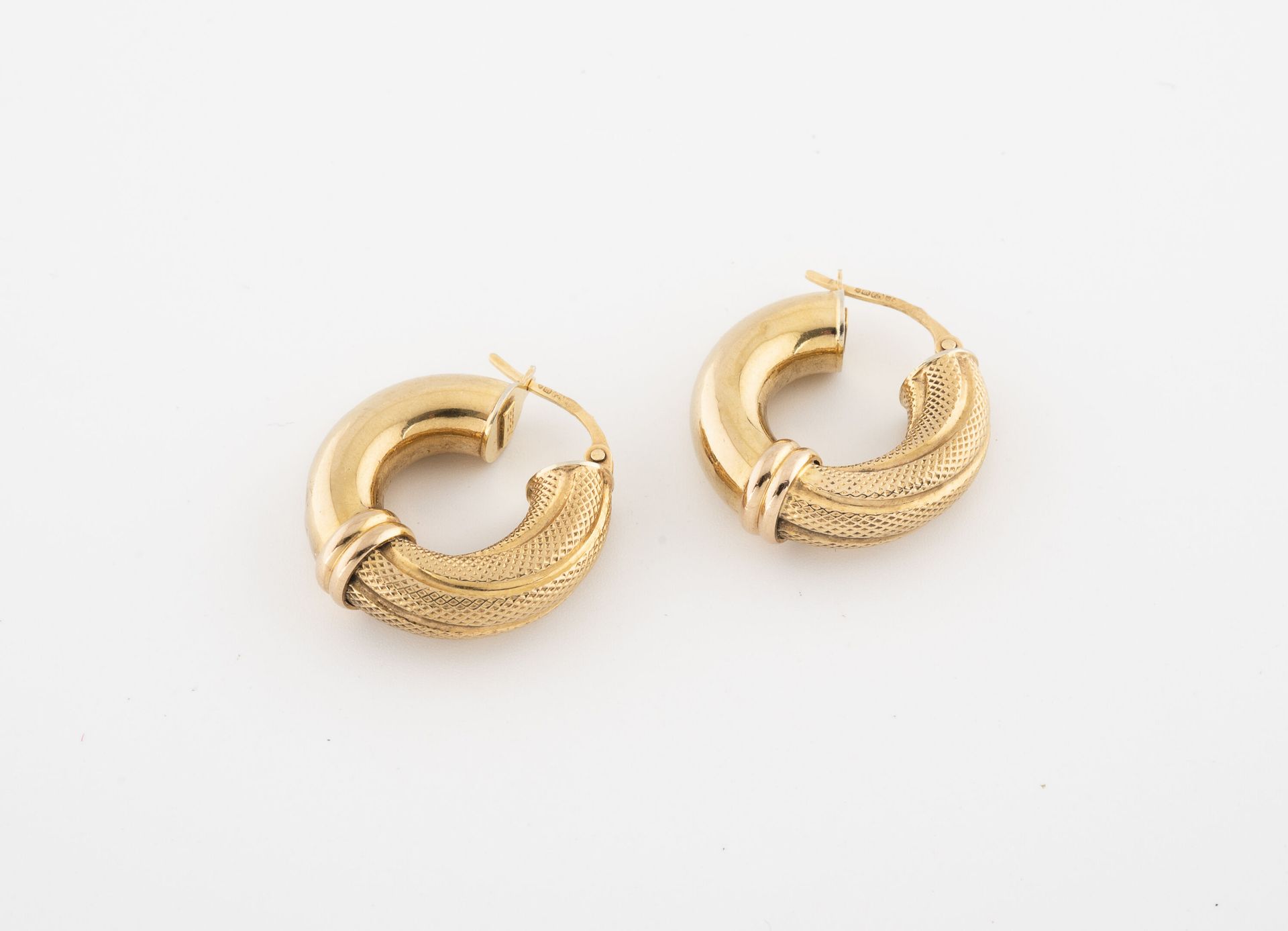 Null Pair of yellow gold (375) hollow creoles, partly guilloché.

System for pie&hellip;