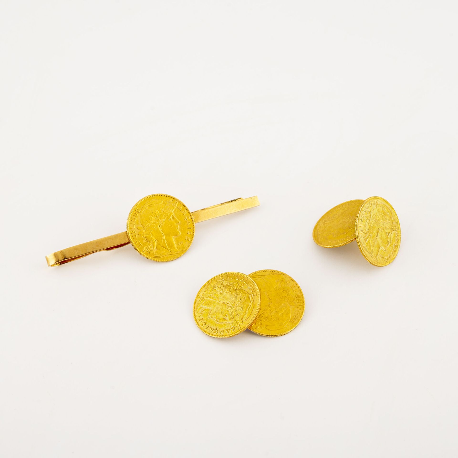 Null 黄金(750)袖扣一对，镶嵌10法郎金币。

总重量：14克。

因使用而产生的划痕。 

ON JOINT :

黄金(750)领带胸针，持有一枚1&hellip;