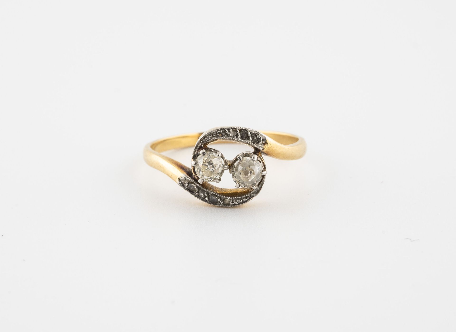 Null 一枚黄金（750）和铂金（850）戒指，拥有两颗爪镶老式切割钻石和两条蜿蜒的种子镶嵌的玫瑰切割钻石。

毛重：2.7克。- 手指大小：56。

刮伤。