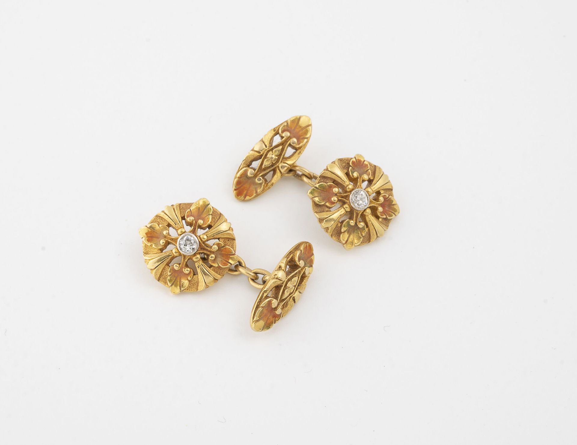 NODEL 一对黄金(750)女士袖扣，上面有部分橙色珐琅的花卉图案，中心有一颗封闭式的小型老式切割钻石。

签名。

总毛重：18克。

划痕；珐琅质的磨损和&hellip;
