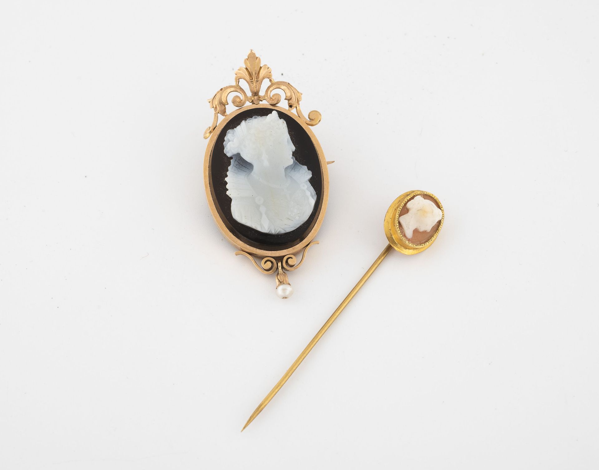 Null 黄金（750）胸针，手持黑白玛瑙上的浮雕，上面有一个穿着领子的女人的轮廓。

黄K金（750）针。

毛重：14.1克。- 高度：5厘米。有轻微磨损和&hellip;