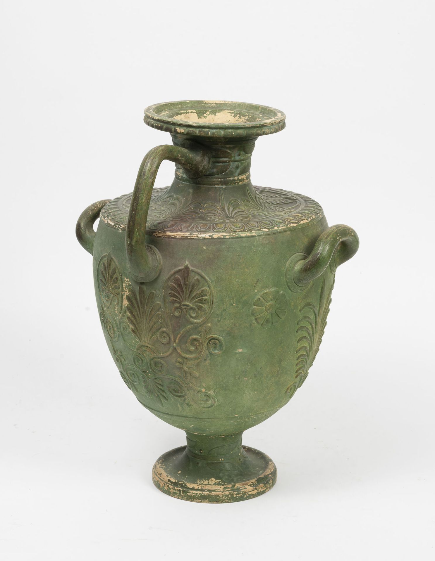 Dans le goût de l'Antiquité 一个绿色铜化的陶瓷花瓶，放在基座上，模仿青铜，装饰有鲜花，棕榈花和一个带翅膀的人物。

有三个把手。

&hellip;