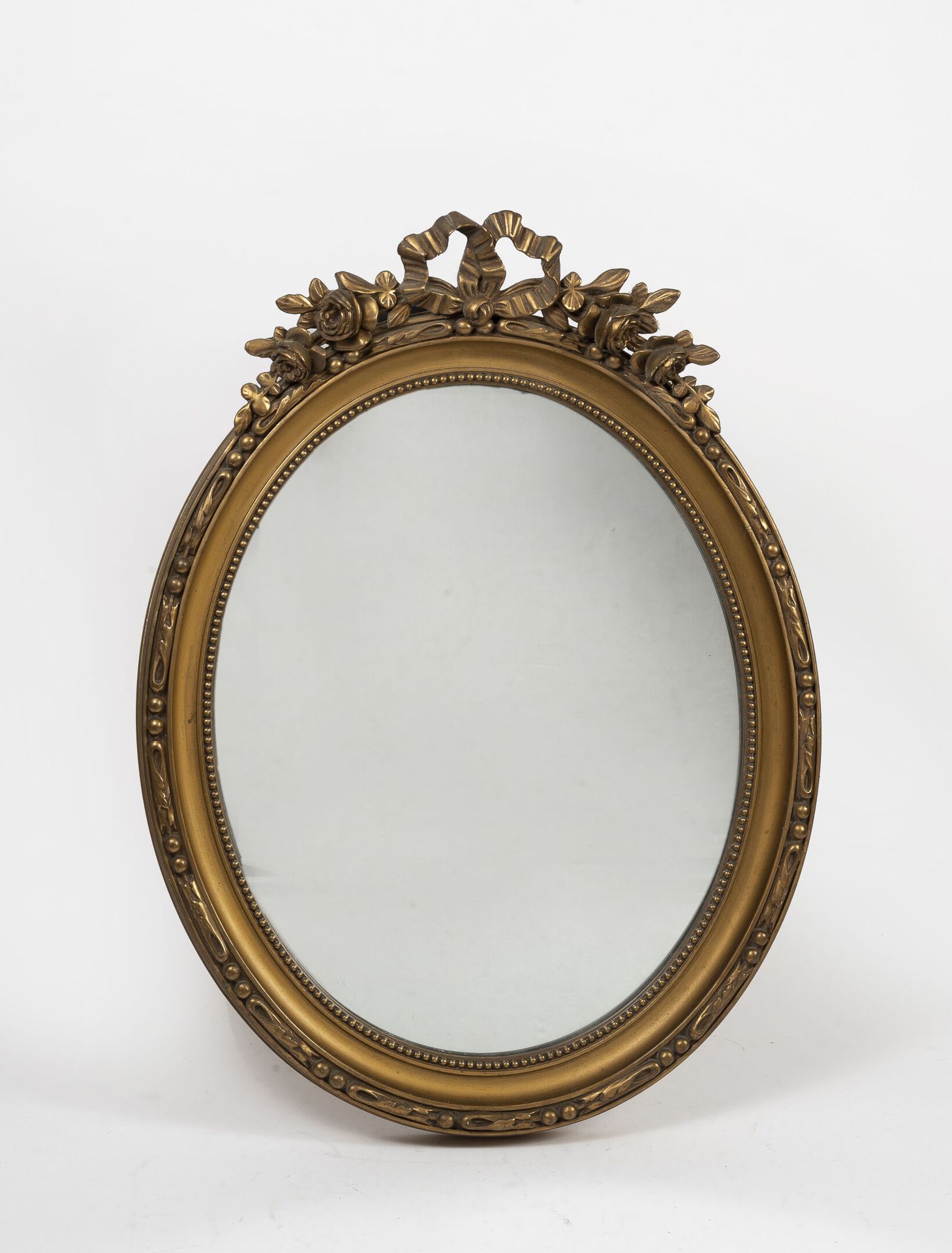 Null Miroir ovale en bois sculpté doré ajouré à décor de fleurs et d'un noeud de&hellip;