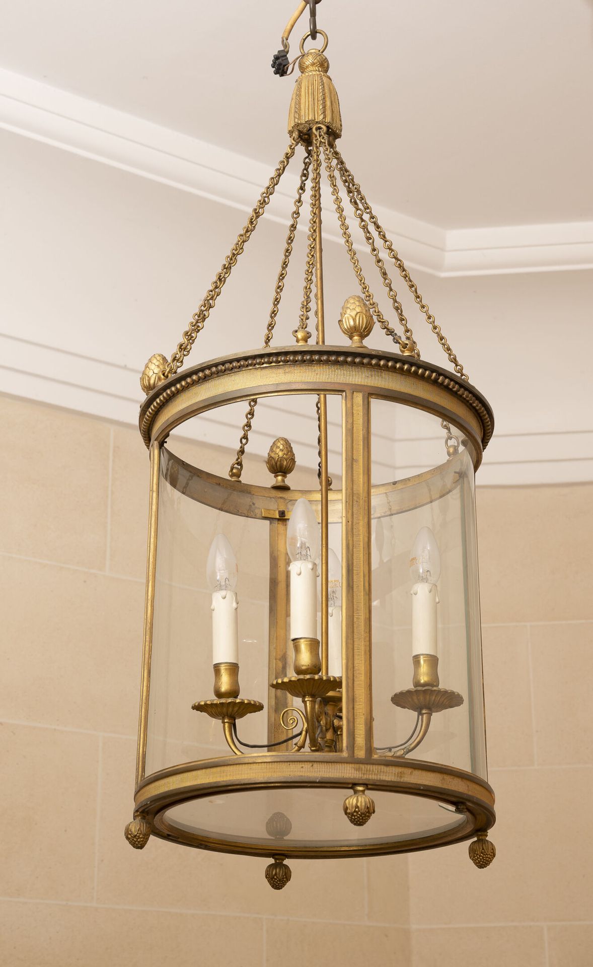 FRANCE, seconde moitié du XXème siècle 一个镀金的青铜和黄铜圆柱形灯笼，有一束四盏灯，顶部的钩子模仿了一个绒球。

路易十&hellip;
