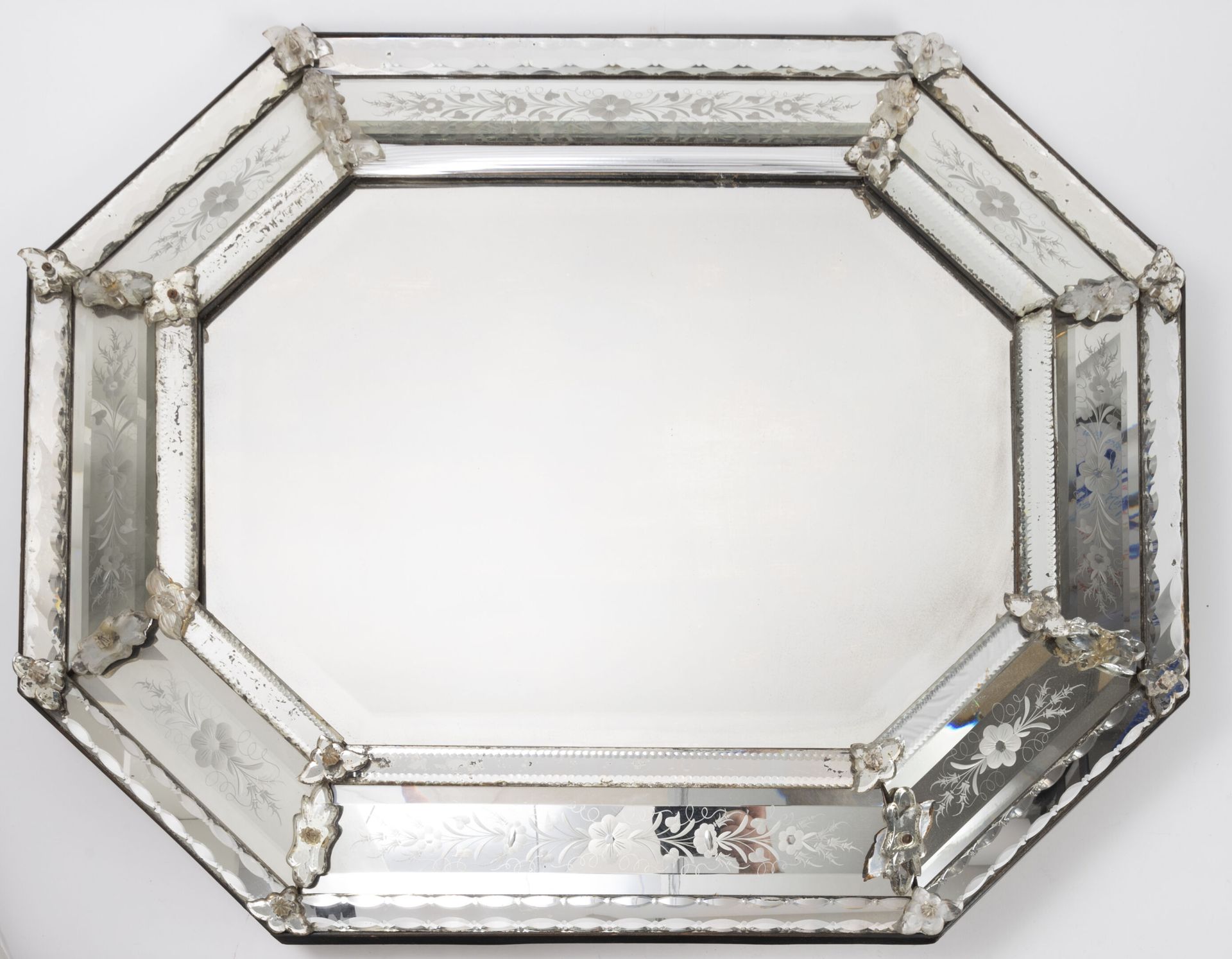 Italie, XXème siècle 八角形的威尼斯镜子，有花纹图案。

88 x 72厘米。

着色剂的磨损、事故、部件的缺失。