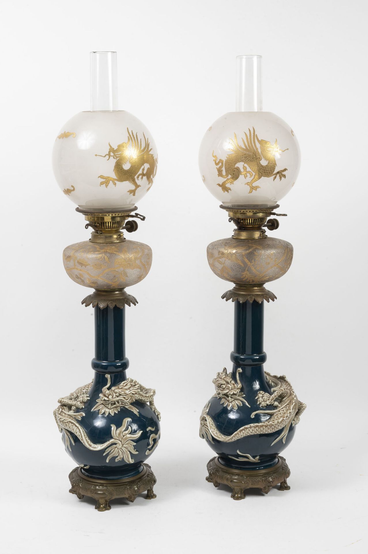 Null 一对蓝色和米色的陶瓷油灯，有龙的装饰。

有龙的球状物。

有镀金鸟的水库。

19世纪。

H.83厘米。

杯子上的薯片。