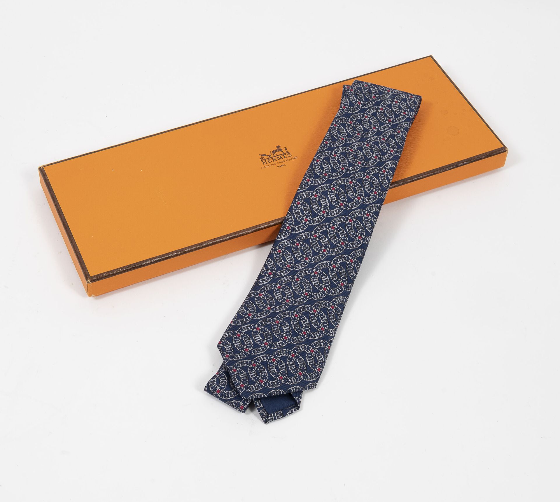 HERMES Paris 蓝色背景的丝绸斜纹领带。

最大宽度：8厘米。

签名。 

小污点。

有原版盒子。