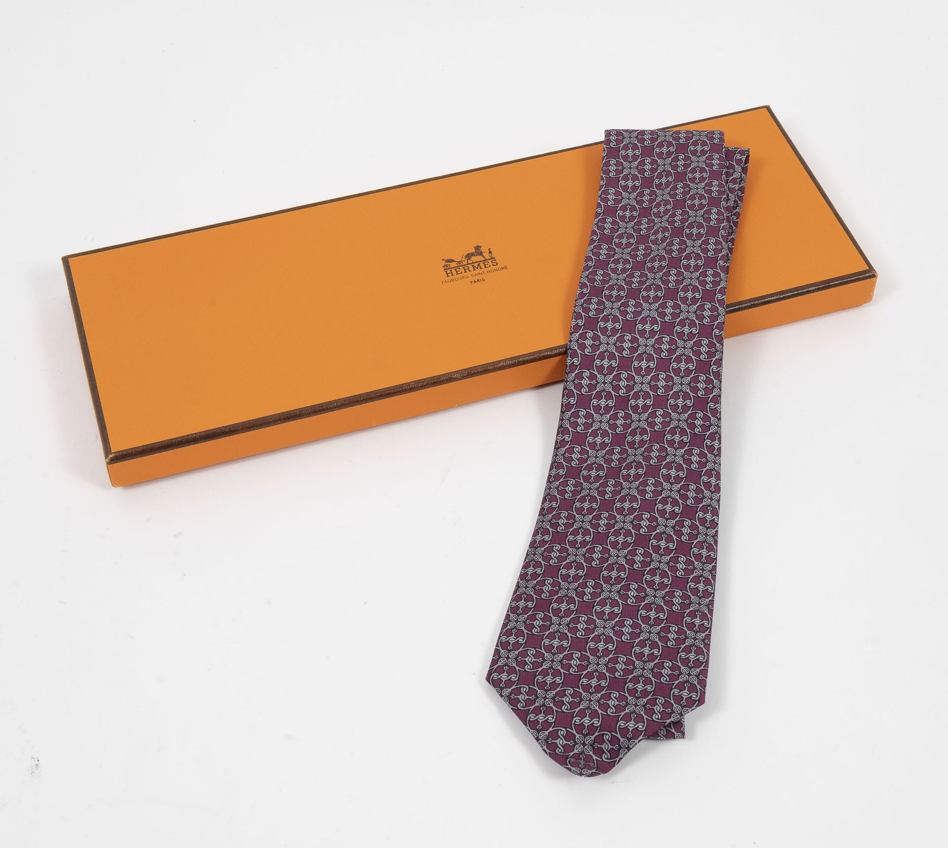 HERMES Paris 晚装斜纹领带，紫色背景上有铁艺图案。

签名。

最大宽度：8.5厘米。

新的条件。

在其原来的盒子里。