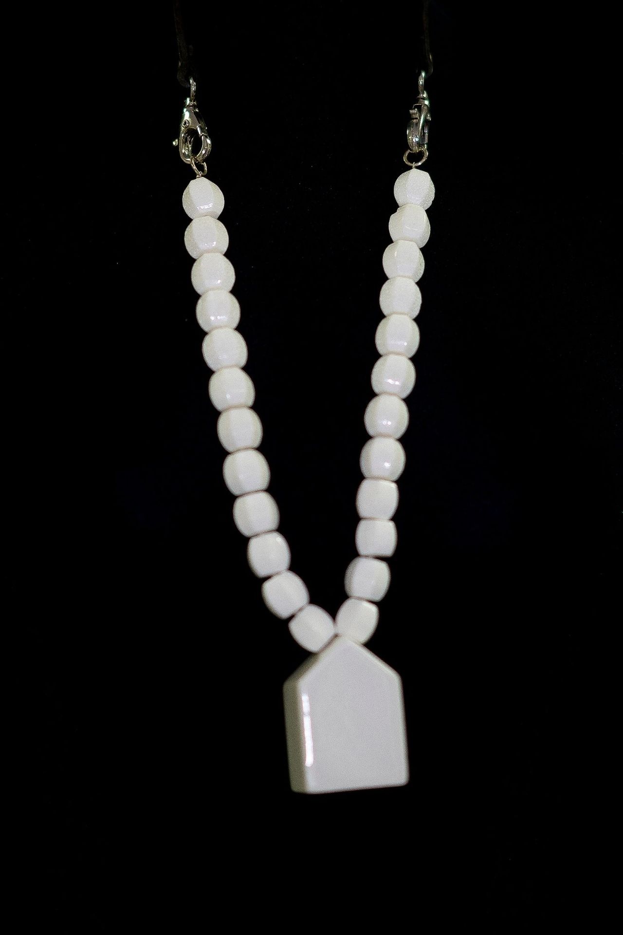 Frédéric HUBIN Maison "项链

八角形珍珠制成的中长项链，装饰有陶瓷Maison吊坠和黑色皮革表带。