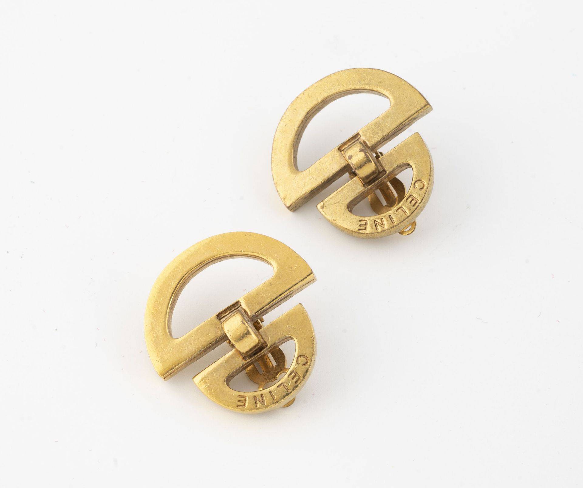 CELINE 一对鎏金金属耳夹，镂空的形式是两个叠加的半圆，有签名。

背面有标记。

用于非穿孔耳的系统。 

磨损和划痕