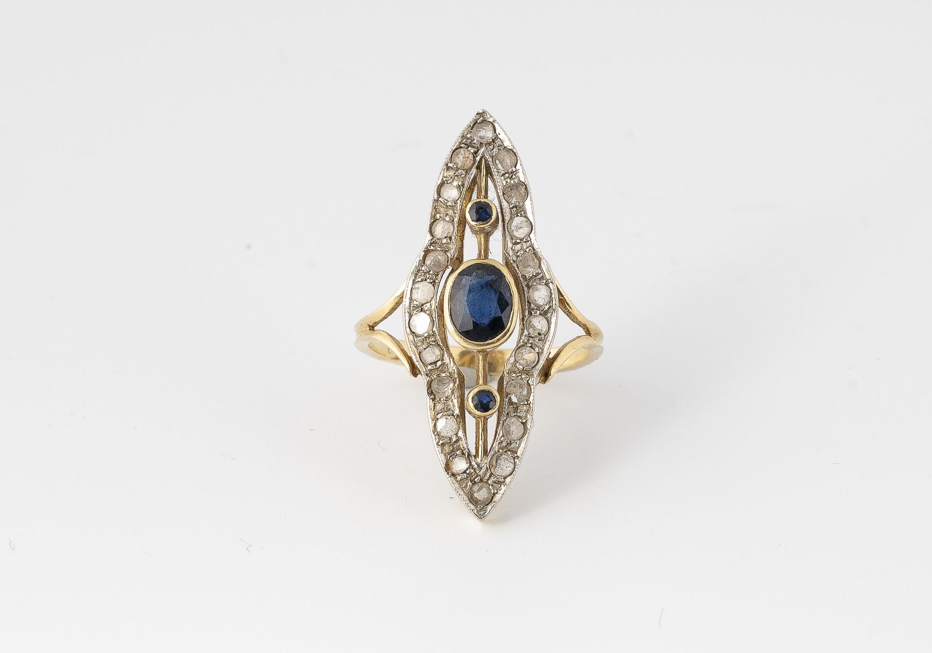 Null 黄金（750）曼陀罗形戒指，以种子镶嵌的方式铺设玫瑰式切割钻石，以封闭式镶嵌的一排椭圆形和圆形蓝宝石为中心。

1920-1930年的工作。

毛重：&hellip;