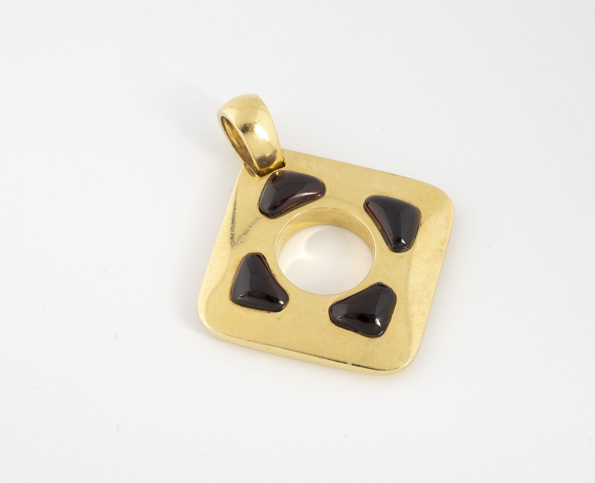 Null 黄金（750）钻石吊坠，中央有一个圆孔，中间镶嵌着四颗凸圆形石榴石。

毛重：29.5克 - 高度（带扣）：5.6厘米。

刮伤，擦伤和小的冲击。