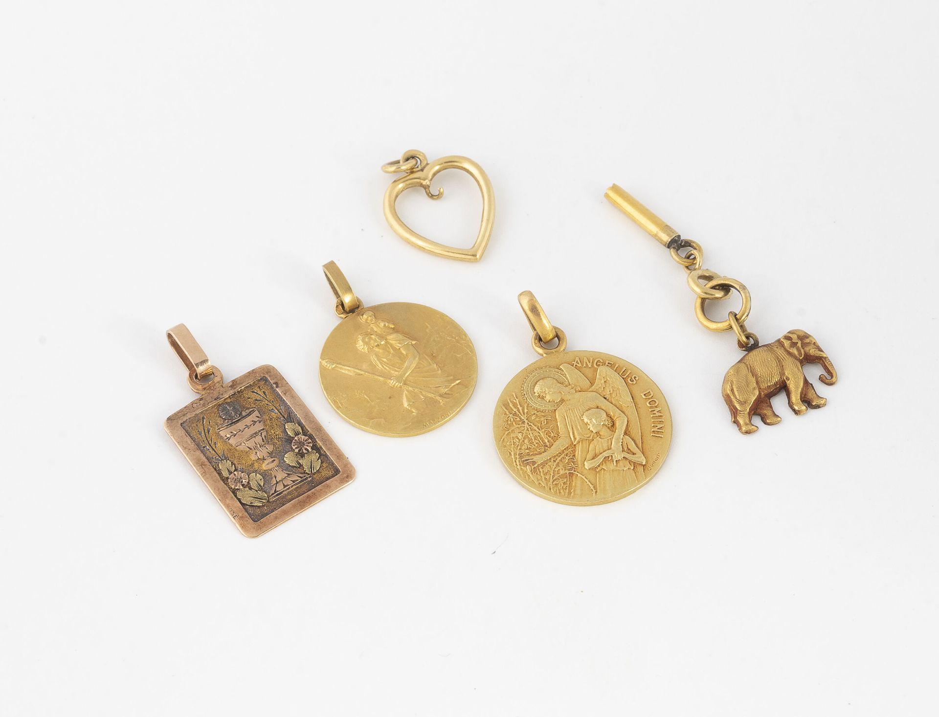 Null 一套黄金（750）首饰包括两个圆形的宗教勋章，其中一个背面没有刻字，一个长方形的三色吊坠，上面有一个花瓶和一个镂空的心形吊坠。

纪念章的直径：2和1&hellip;