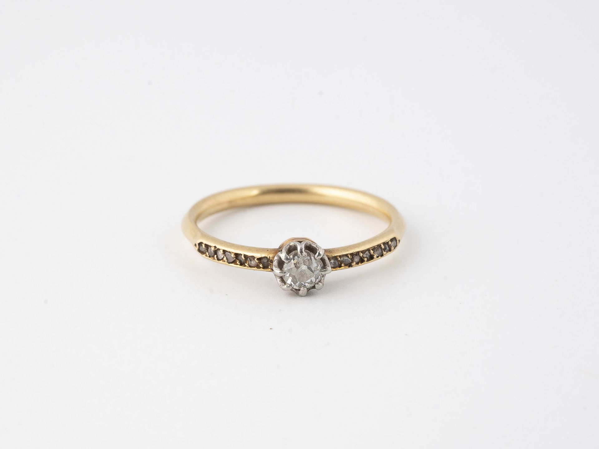Null 黄金（750）和铂金（750）戒指，以爪式镶嵌的老式切割钻石为中心，并镶嵌小型玫瑰切割钻石。 

毛重：2.1克 - 手指尺寸：53

磨损和撕裂。