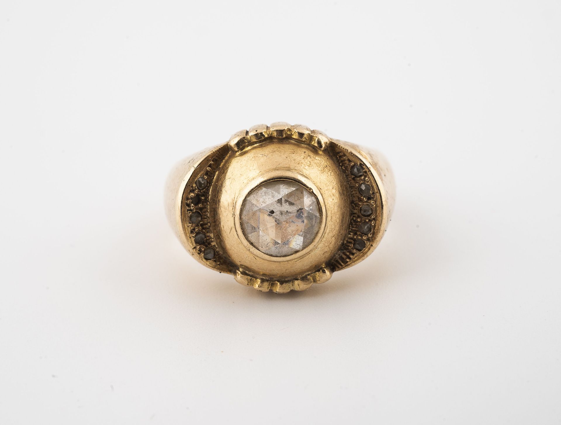 Null 黄金（750）圆顶戒指，以一颗封闭式镶嵌的荷兰玫瑰钻石为中心，周围环绕着石榴花图案，两翼铺设有种子镶嵌的玫瑰切割钻石。

毛重：8.2克 - 手指大小&hellip;