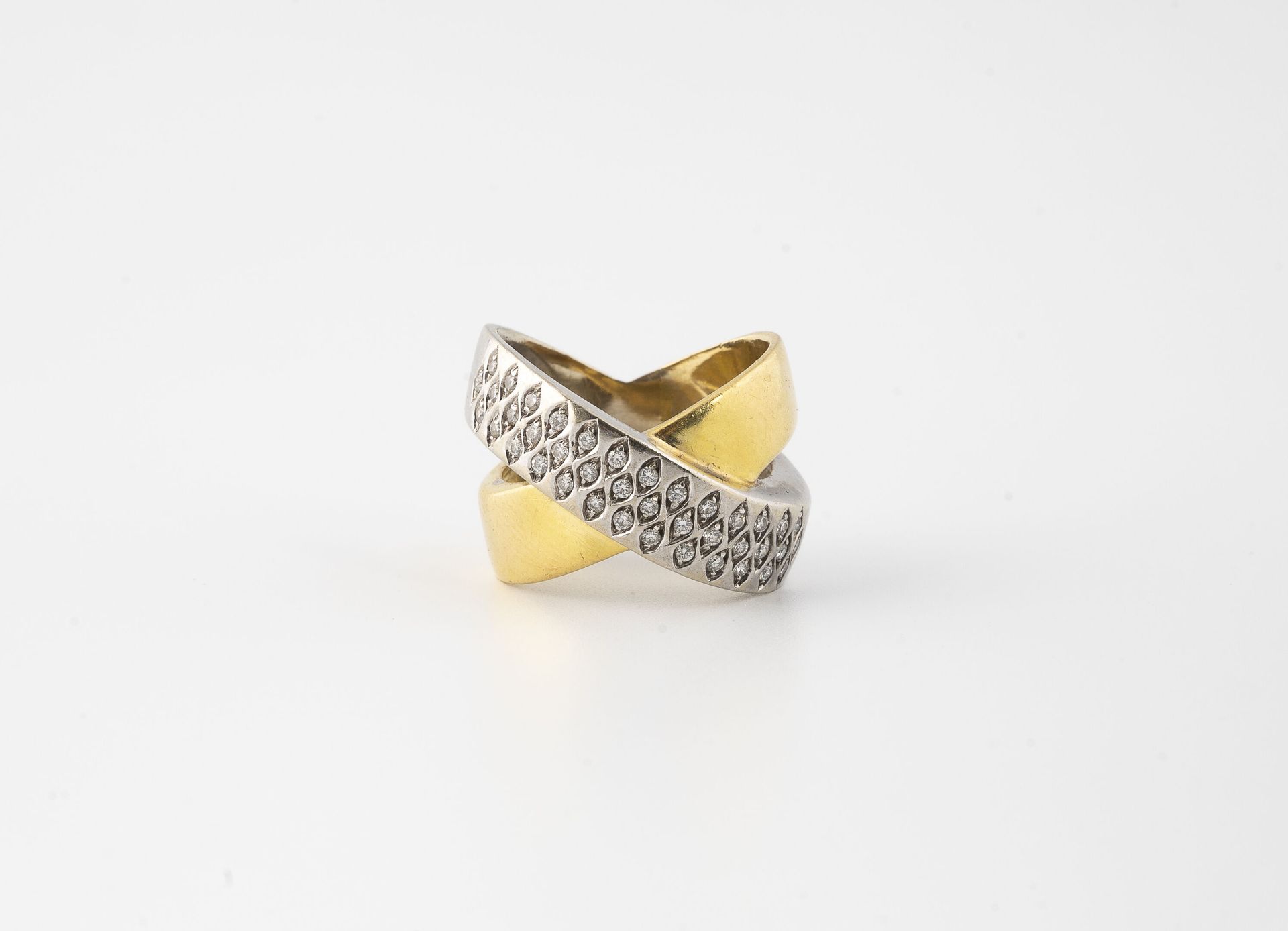 Null 黄白金（750）戒指，有两个交错的环，其中一个镶有明亮式切割钻石。

毛重：14.7克 - 手指大小：57。

刮伤和擦伤。