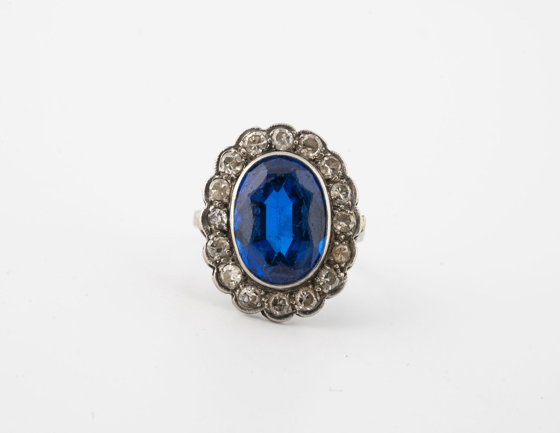 Null 漂亮的铂金(850)雏菊戒指，镶嵌着一颗椭圆形的蓝宝石，在珠状的小八角形钻石衬托下。

毛重：4.5克 - 手指大小：52。

刮痕，擦伤和小碎片。