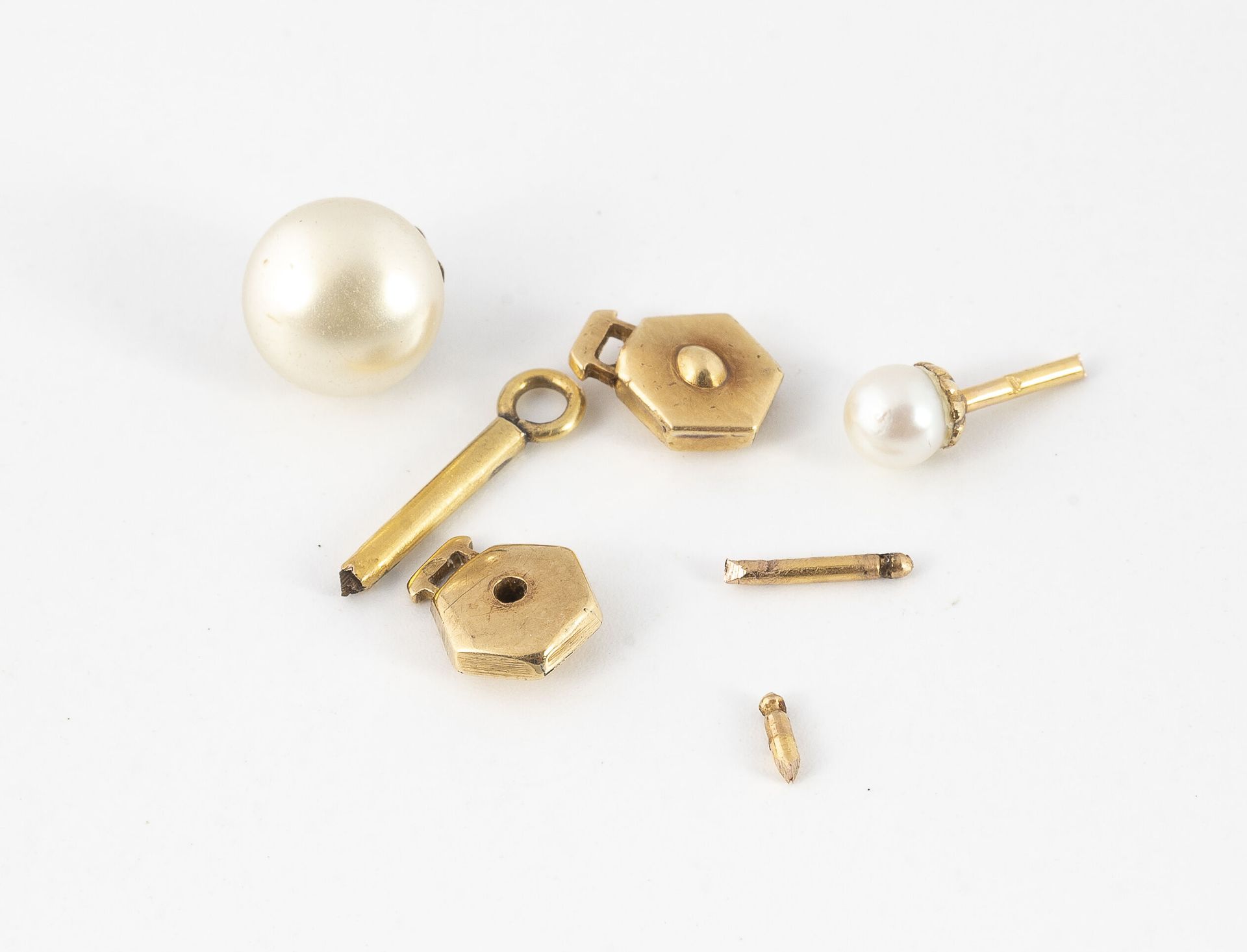 Null 一套两个黄金(750)螺柱，配以白色养殖珍珠和一个发条钥匙。

总毛重：2.7克。

附有一个意外的鎏金金属搭扣。