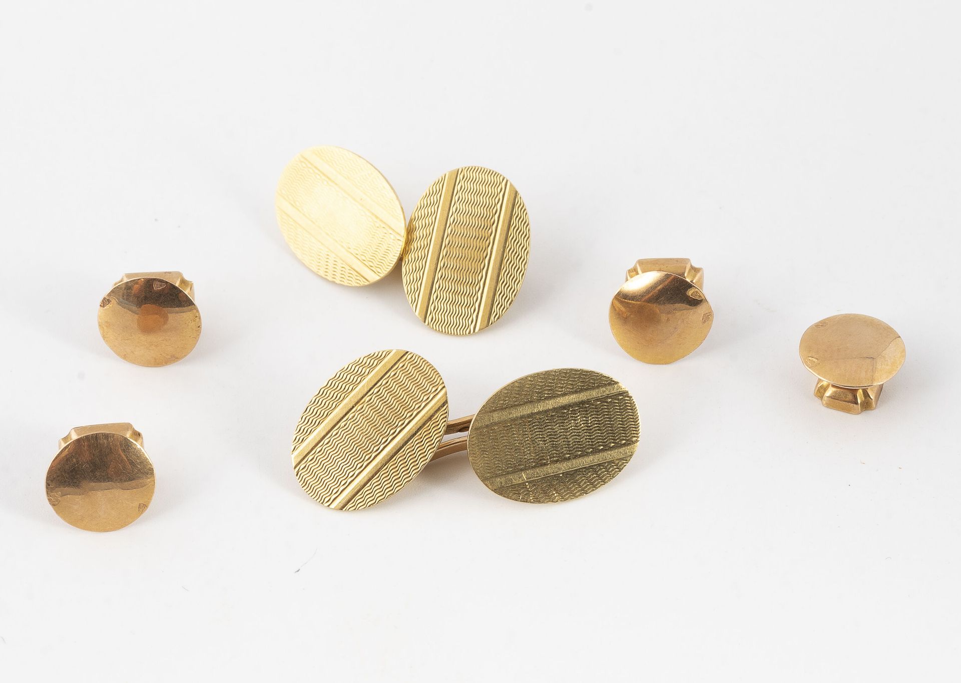 Null 一对椭圆形的黄金（750）袖扣，上面有凹凸不平的条纹，两对圆形的黄金（750）领扣。

总重量：10.2克。- 袖扣的高度：1.6厘米 - 项链的直径&hellip;