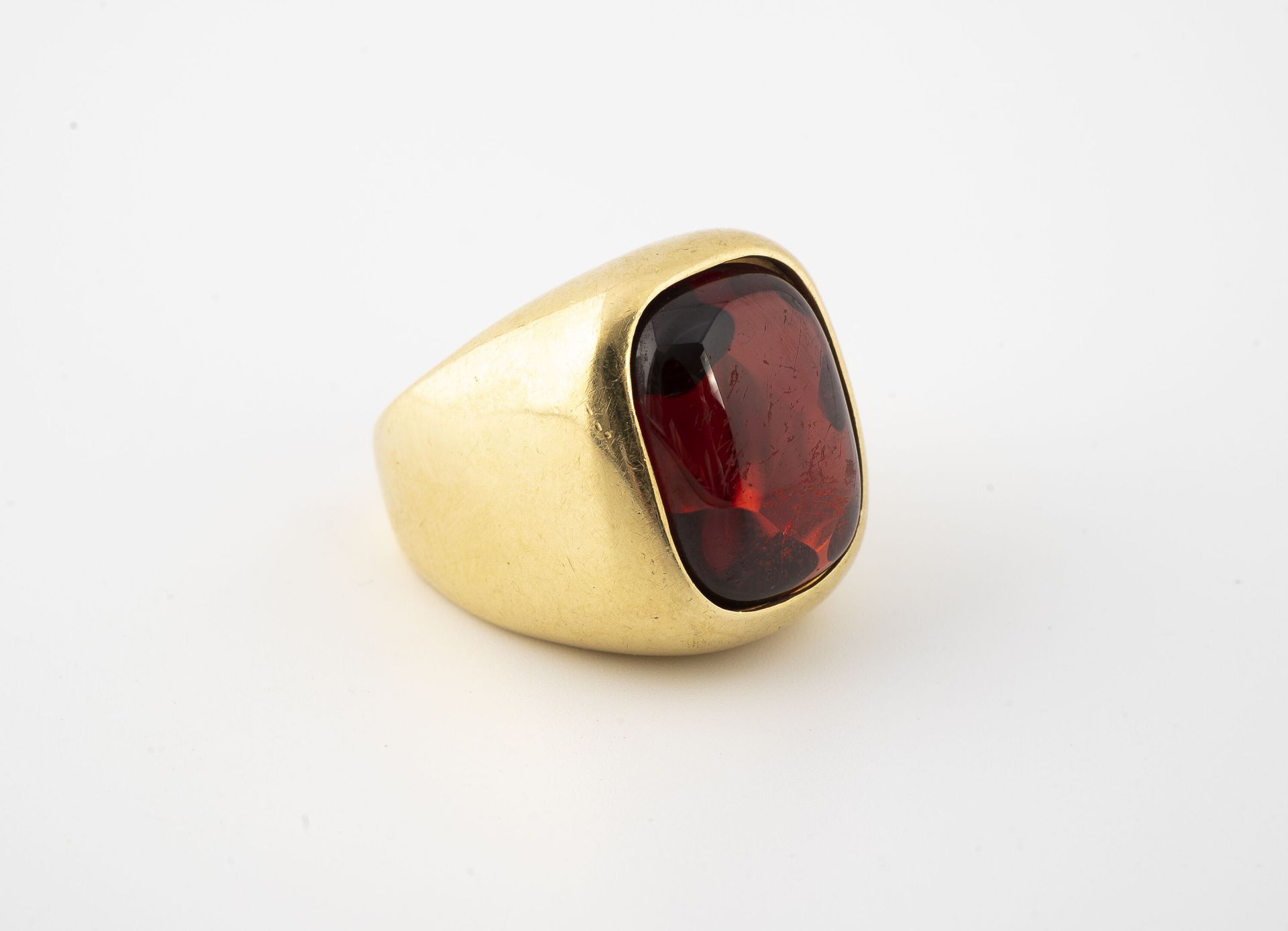 Null 
黄金（750）签章戒指，镶有一个大的长方形凸圆形，有圆角的合成红棕色石头，背面用爪子镶嵌。

毛重：18.2克 - 手指大小：56。 

刮伤，擦伤&hellip;