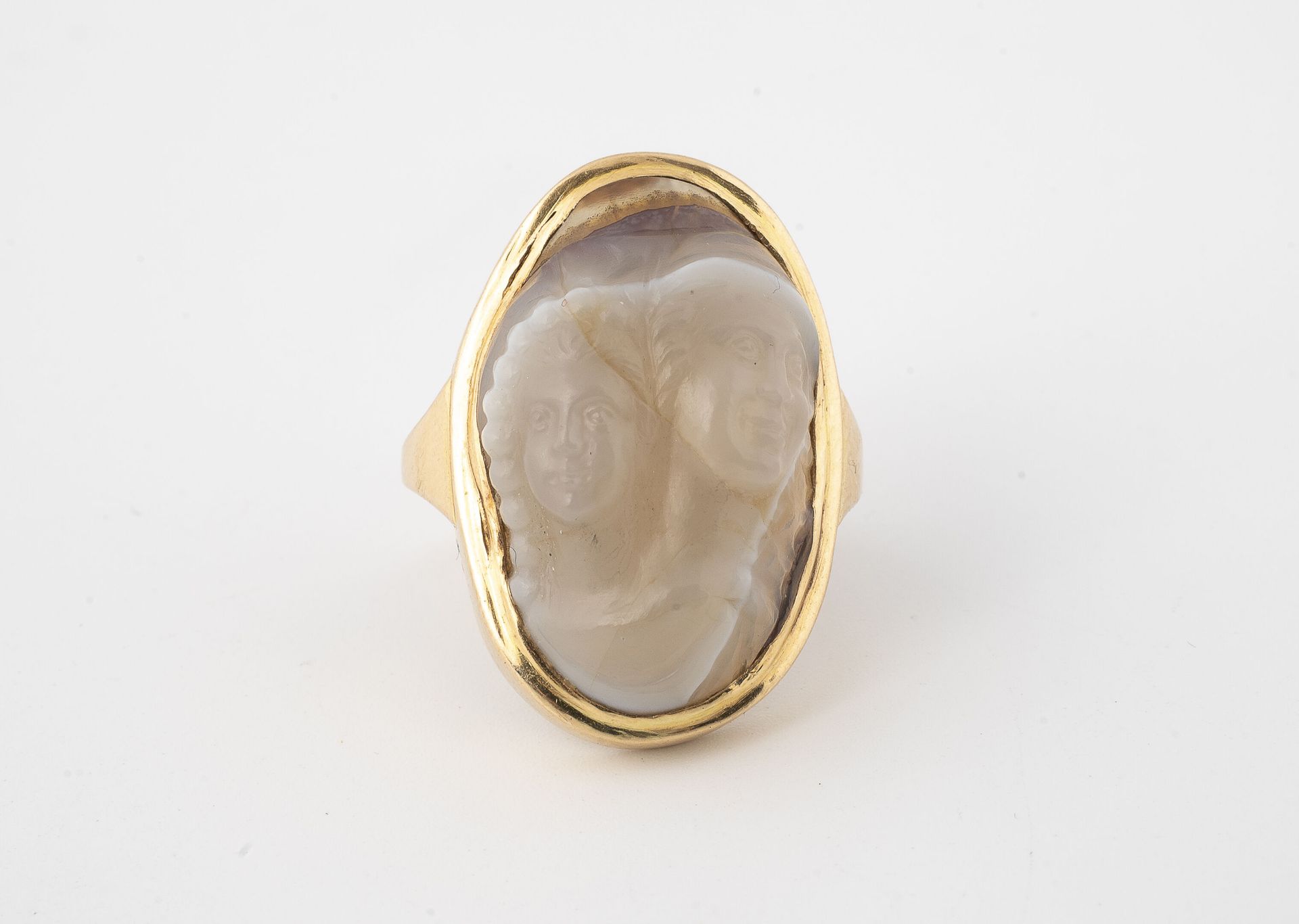 Null 
黄金（750）戒指，以玛瑙上的浮雕为中心，代表两个头，封闭式镶嵌。 

毛重：11.8克。- 手指大小：46。

生长裂缝；变形的环。