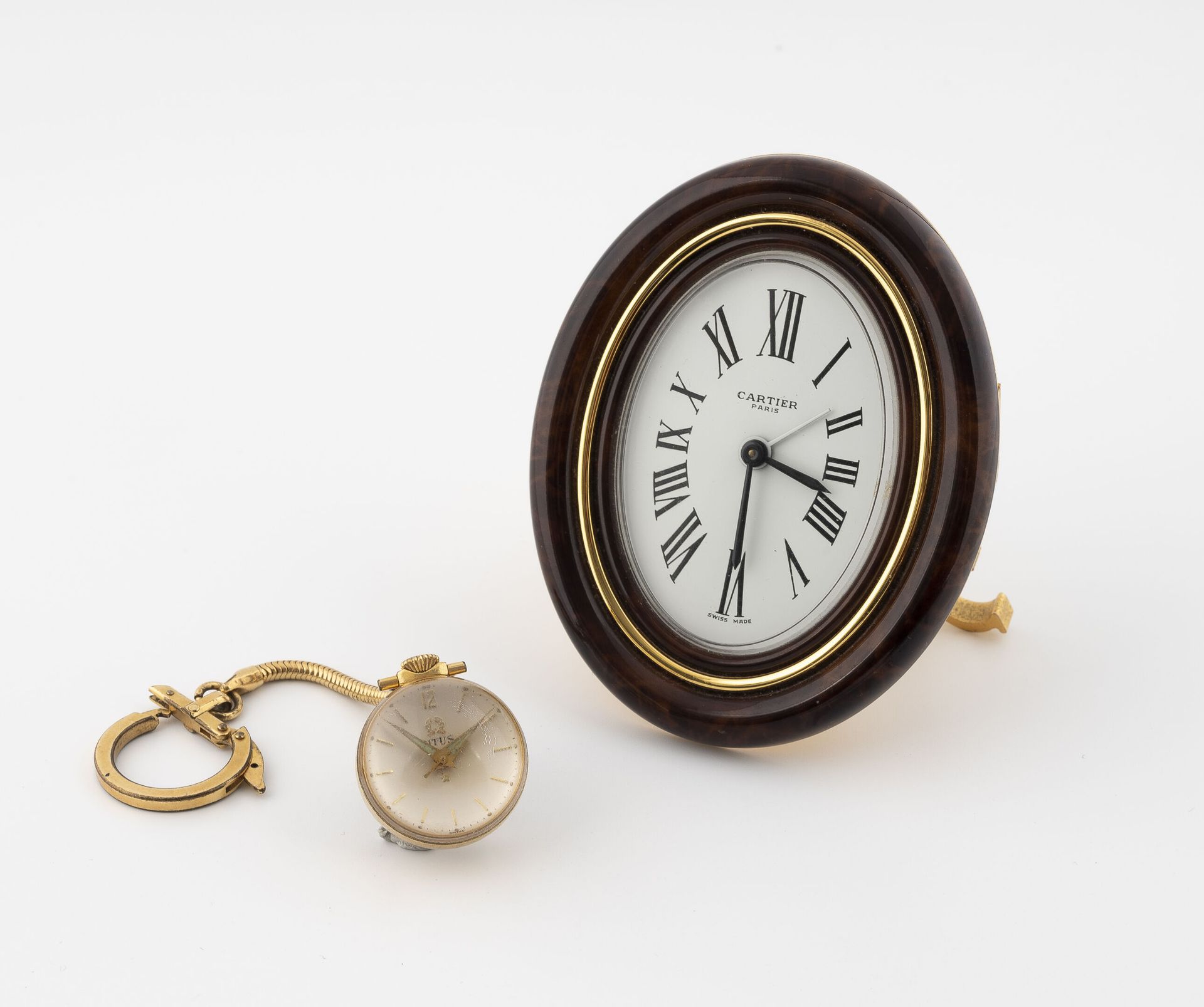 CARTIER Oval clock in gilded metal lacquered brown in imitation of wood. 
White &hellip;