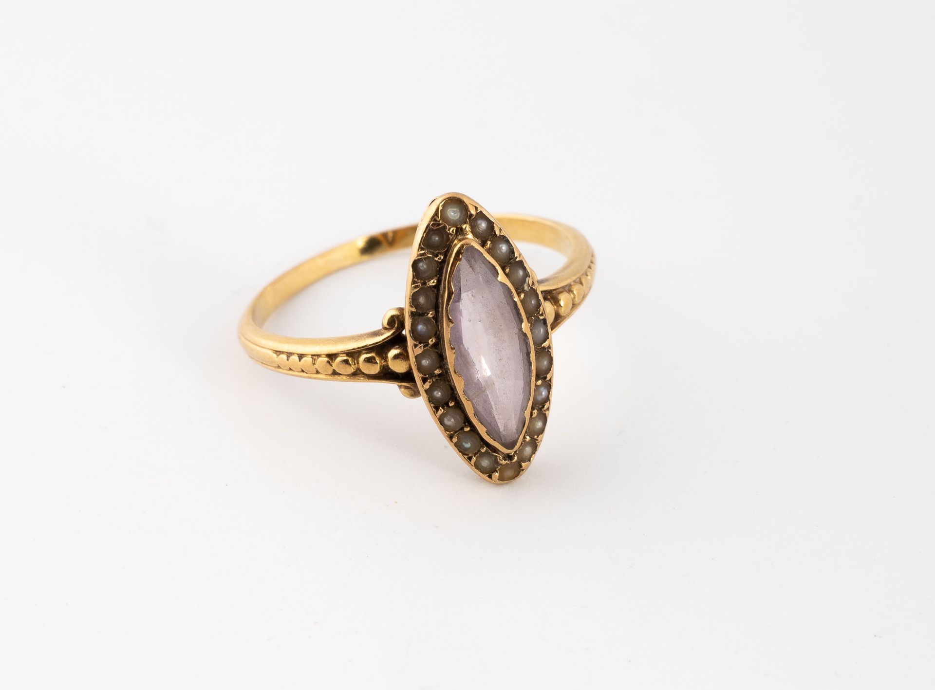 Null 黄金（750）戒指，在一圈白色的小养殖珍珠中镶嵌了一颗椭圆形的切面紫水晶。
毛重：2.4克。- 手指尺寸：55。 
有划痕和磨损。