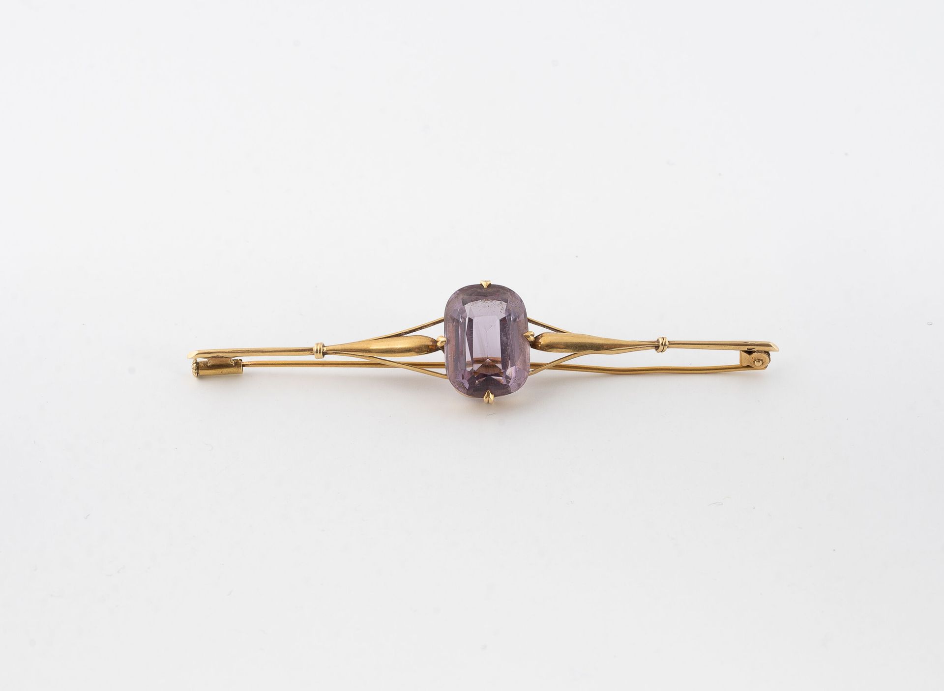 Null 黄金(750)胸针，中心为枕形切割紫水晶。 
黄金（750）胸针。
毛重：6.7克 - 长8厘米。 
针脚有扭曲，有缺口。