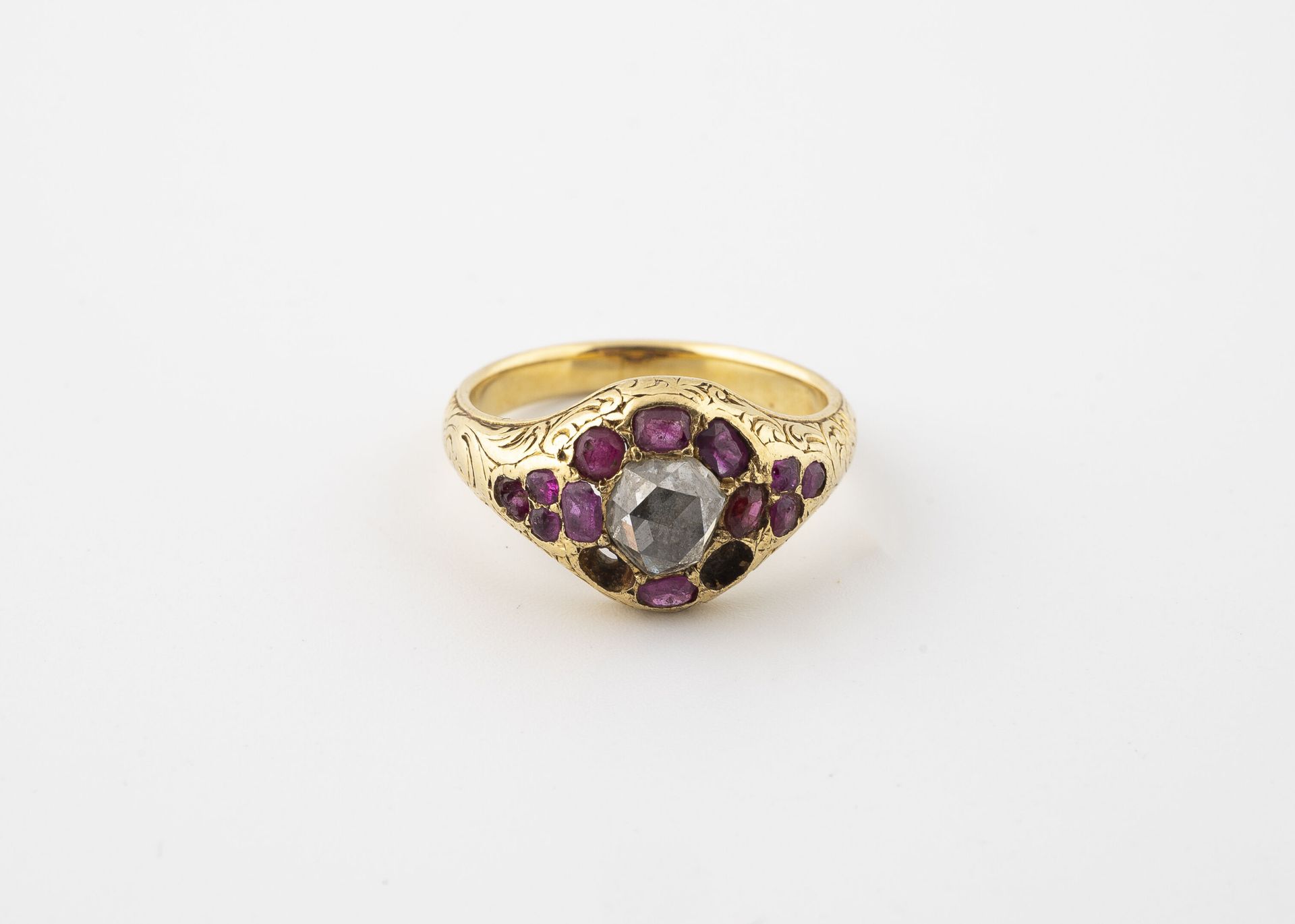 Null 黄金（750）雏菊戒指，以玫瑰切割钻石为中心，镶嵌刻面红宝石。 
毛重：6.0克。- 手指大小：52。
两颗红宝石缺失，略有变形。