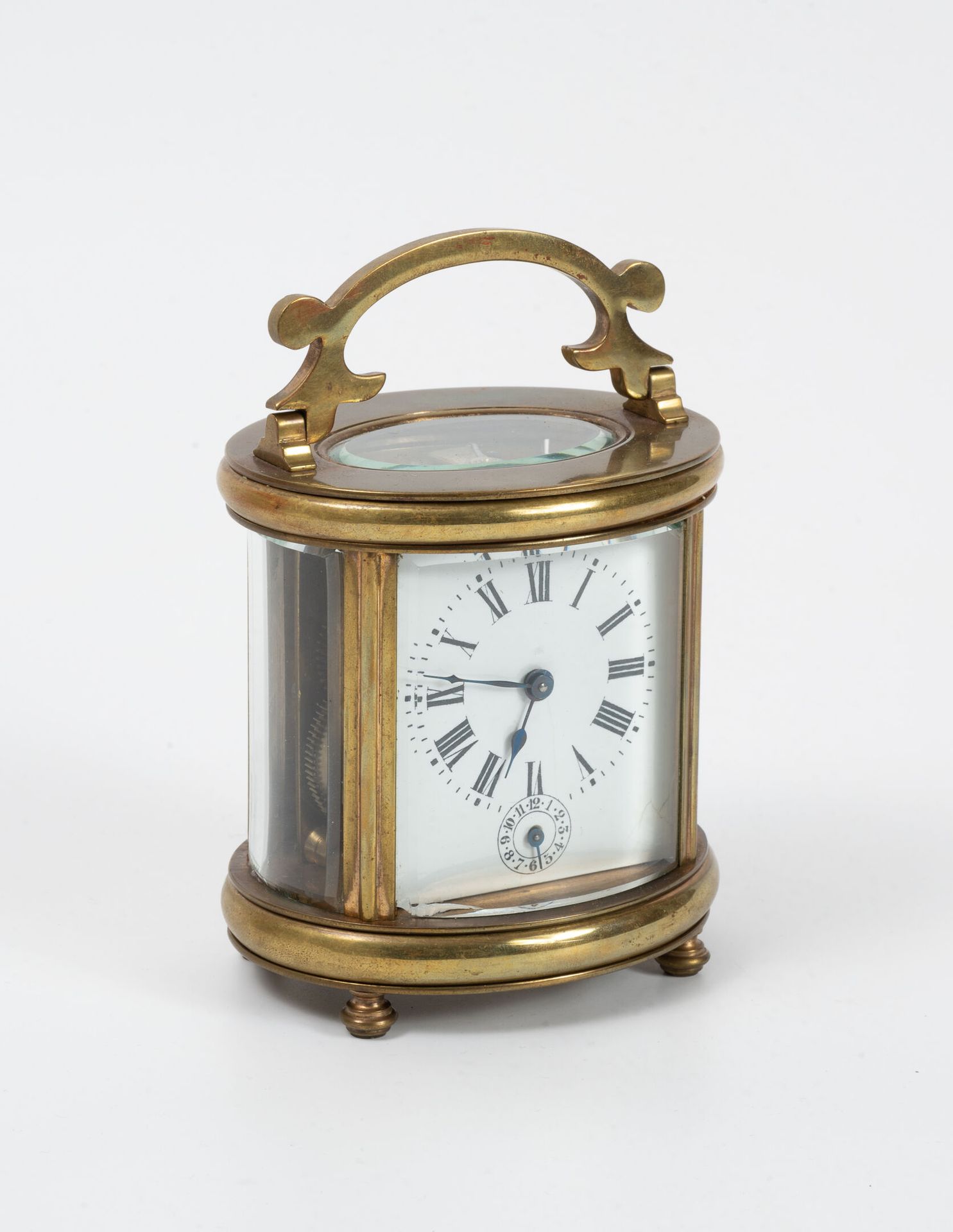 Null Clock of officer in gilded brass. 
Oval glass cage and beveled, resting on &hellip;