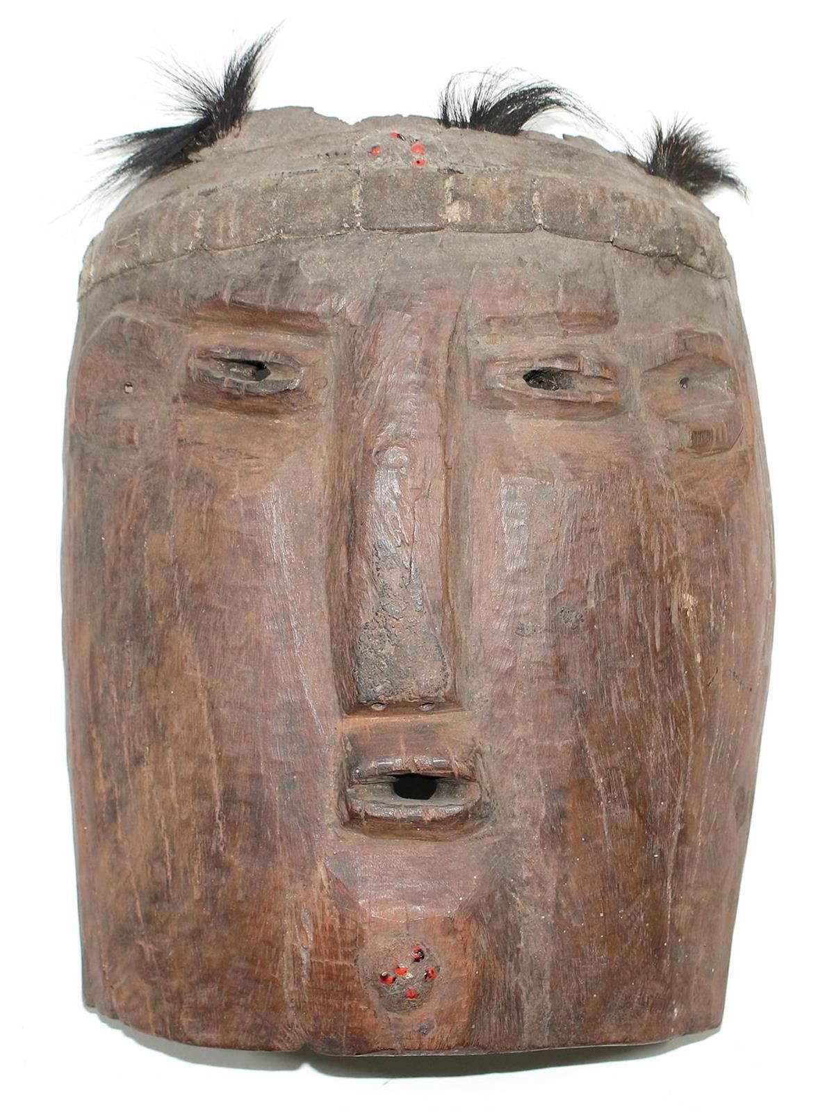 Mbunda Brettmaske 赞比亚。弧形盾牌形状的板状面具。眼睛、耳朵和嘴巴看起来很小。额头和下巴的胡须有红色的种子。修剪头发。皮革头带。33 x 27&hellip;