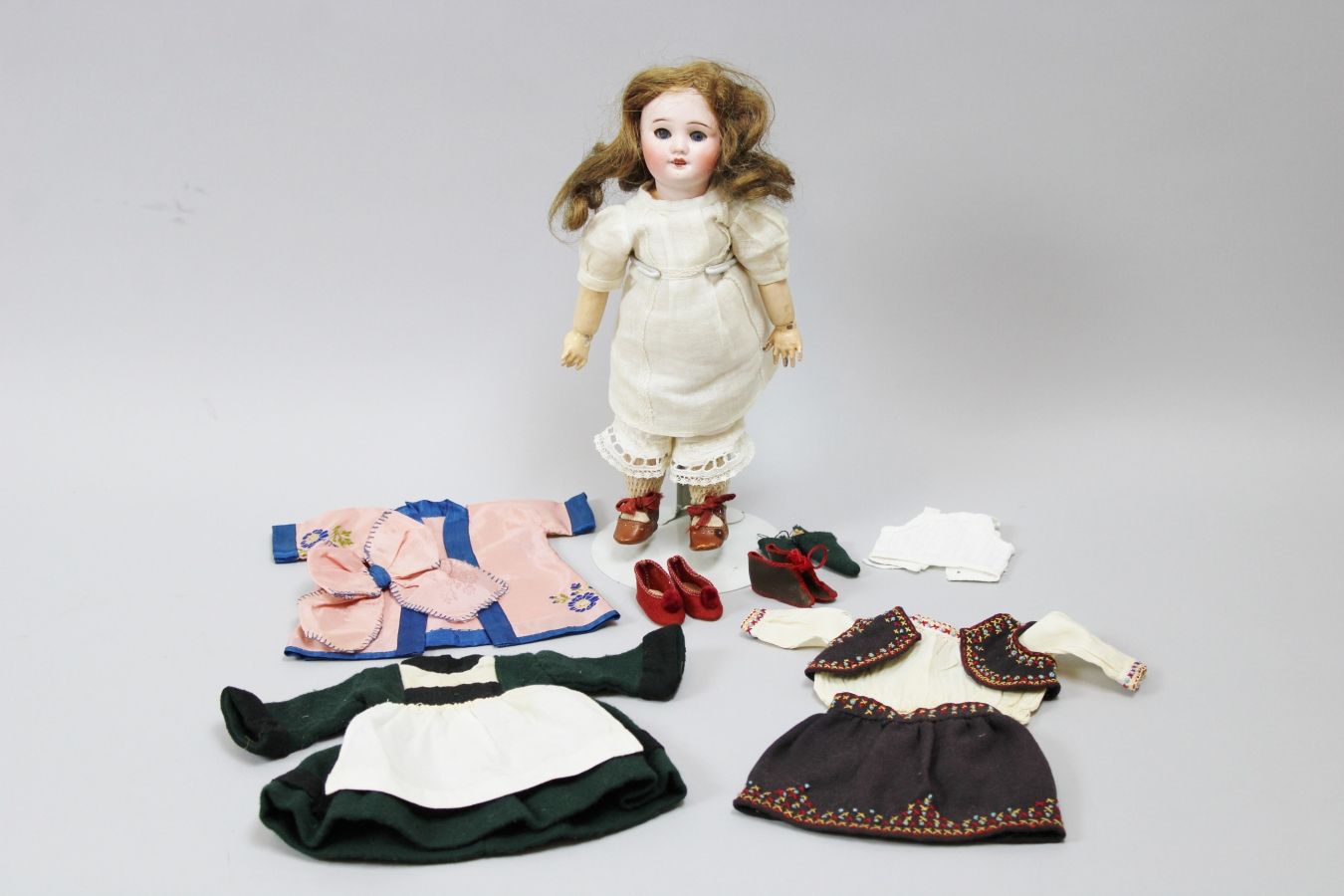 Null Bleuette娃娃，瓷质头部标有SFBJ 60 8/0（额头有裂纹），蓝色的活动眼睛，张着嘴有一排牙齿，棕色假发。木质和合成材料的铰接式身体（有些小&hellip;