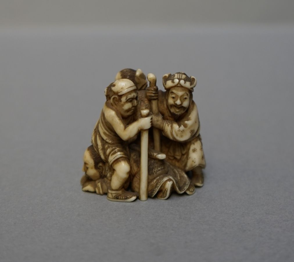 Null OKIMONO in patinated ivory with four armed characters. Tiny accident at the&hellip;