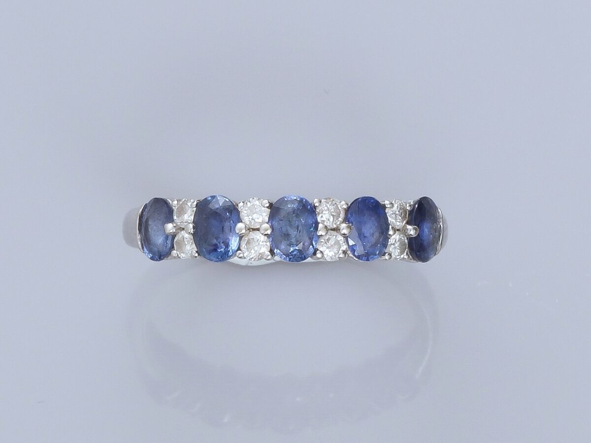 Null 18K白金戒指，镶有5颗椭圆形蓝宝石（共约1克拉），与明亮式切割钻石交替。TDD 54.宽度：4毫米。鹰头标志
