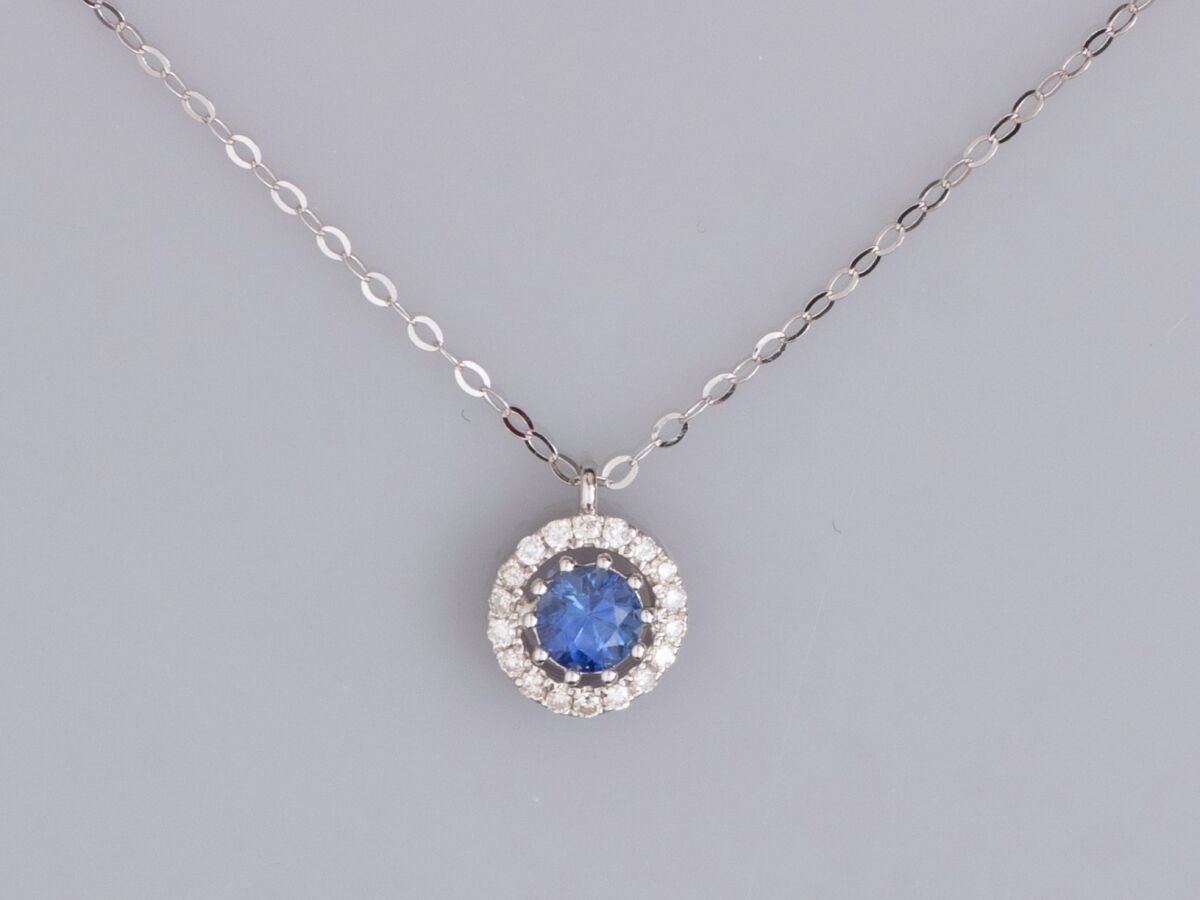 Null 18K白金精致项链，镶有一颗约0.20克拉的小圆蓝宝石，周围有小的明亮式切割钻石，重0.8克。长：40至45厘米。直径6.9毫米。鹰头标志
