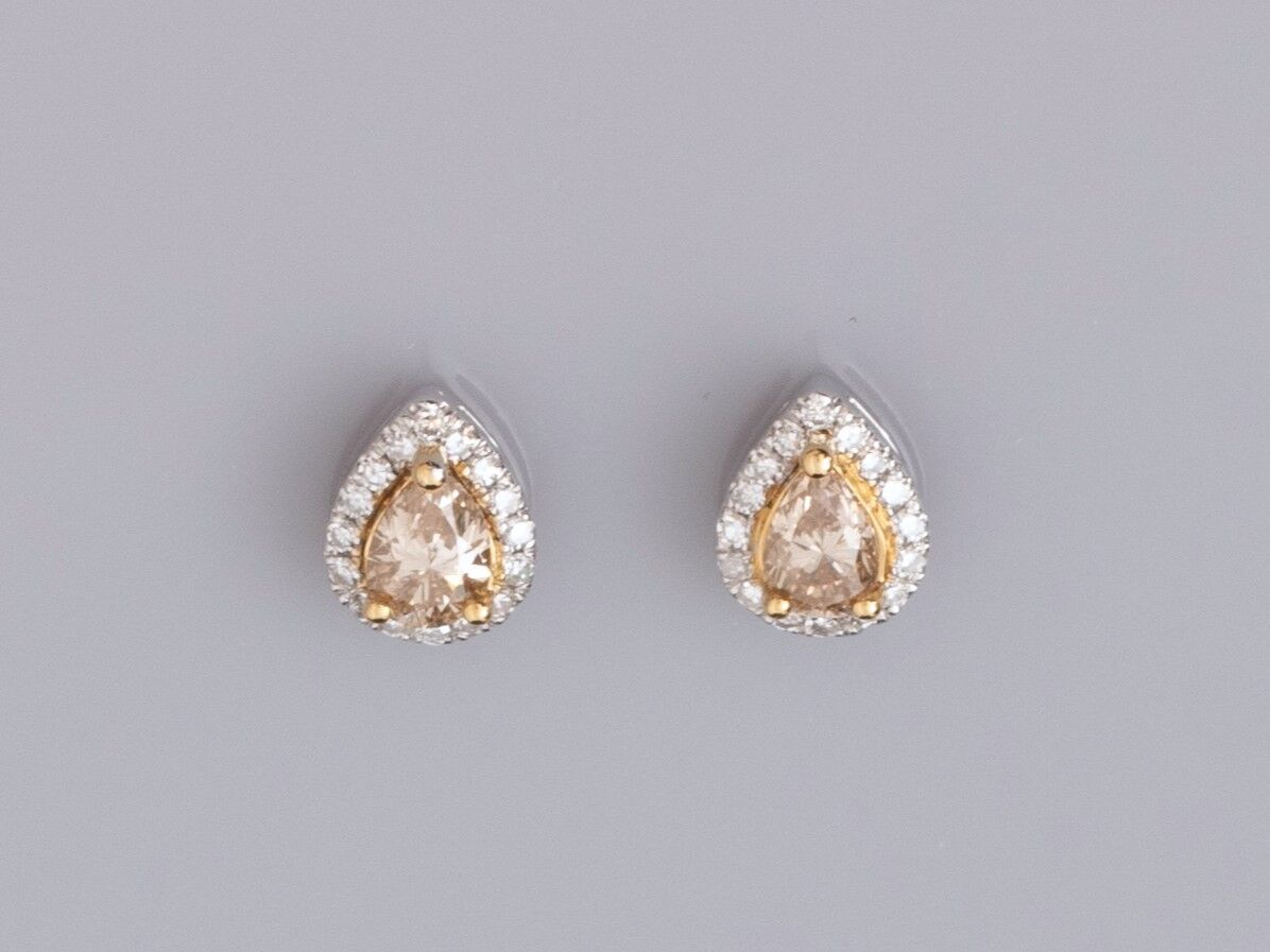 Null 一对750°/00白金耳环，每只耳环都镶嵌了一颗梨形切割的香槟钻石（约0.20克拉），周围是明亮式切割的钻石，1.6克。高：7.5毫米。推杆式扣件。鹰&hellip;