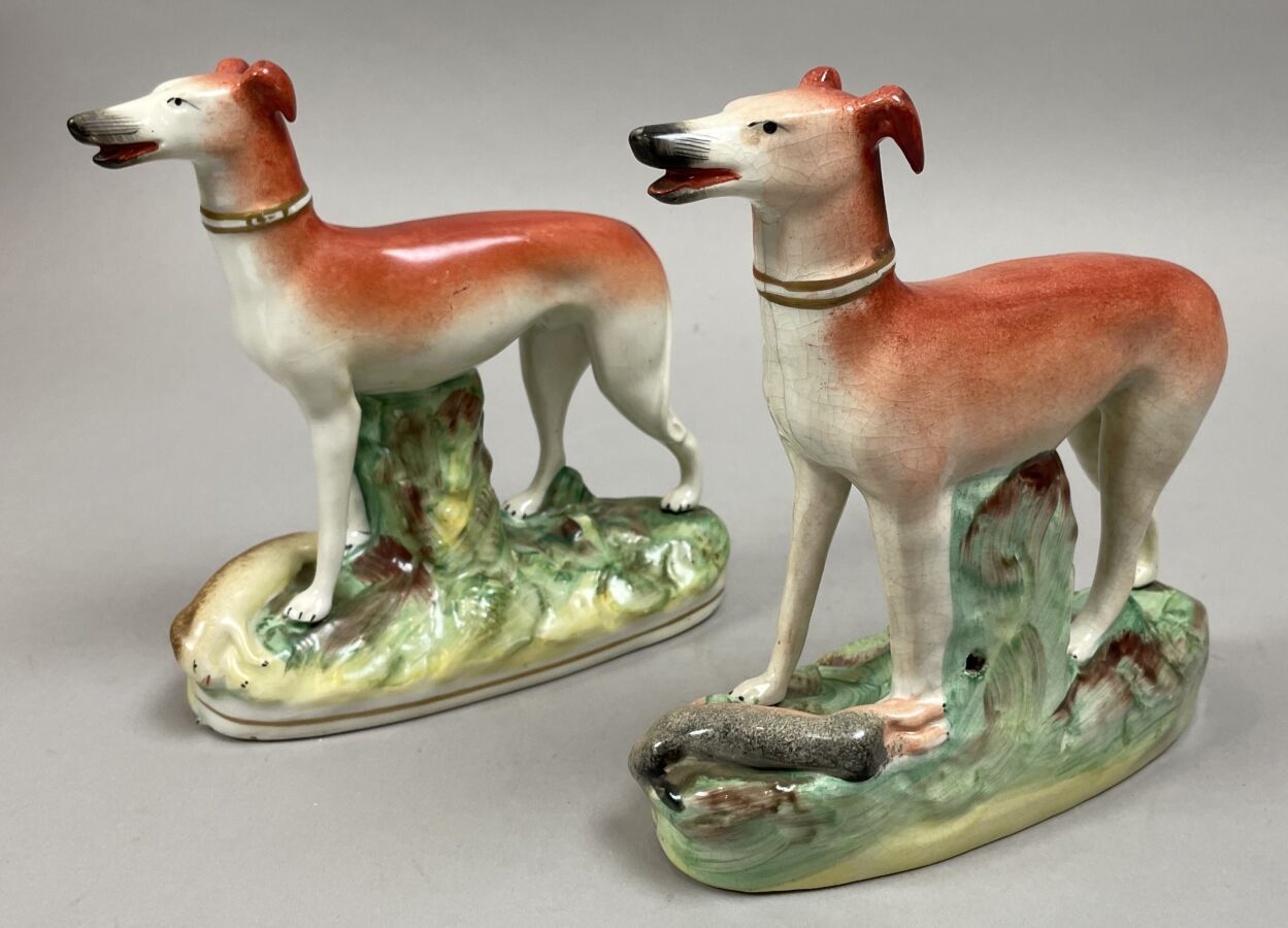 Null 斯塔福德郡。英国。两个灰狗的雕像站在一个椭圆形的底座上，两腿之间有一只野兔。多色装饰。19世纪。高度：18和16厘米。18和16厘米。其中一个的底座下&hellip;