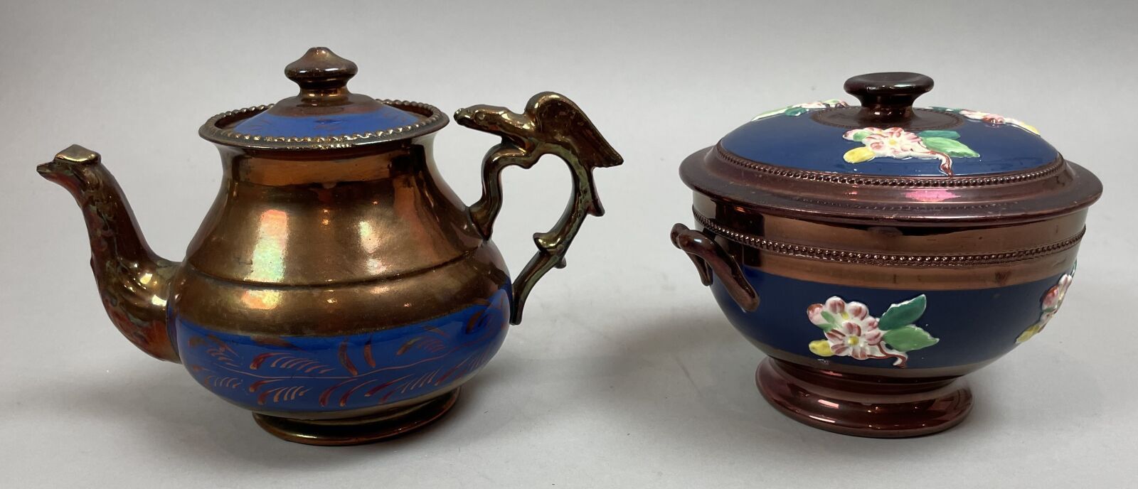 Null 一个蓝色的 "老鹰 "茶壶，有一个鸟头的壶嘴和一个卷轴手柄，上面有一只老鹰，有铜光泽和铜叶带装饰。高：13厘米。壶嘴末端有缺口；维多利亚时期。类似的模&hellip;