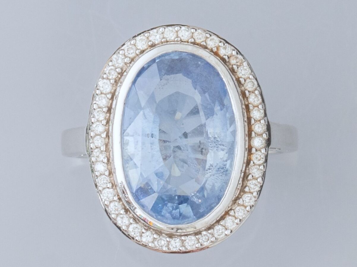 Null 18K白金戒指，镶嵌着一颗椭圆的淡紫色蓝宝石，重约7克拉（分离面），周围是小型明亮式切割钻石。TDD 55.长度：19.2毫米。鹰头标志