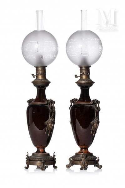 Paire de lampes à pétrole 以牛血色瓷器柱形花瓶的形式，青铜框架上装饰着古色古香的面具，拿着滚动的把手。枝繁叶茂的底座，有卷轴式或护筒式&hellip;
