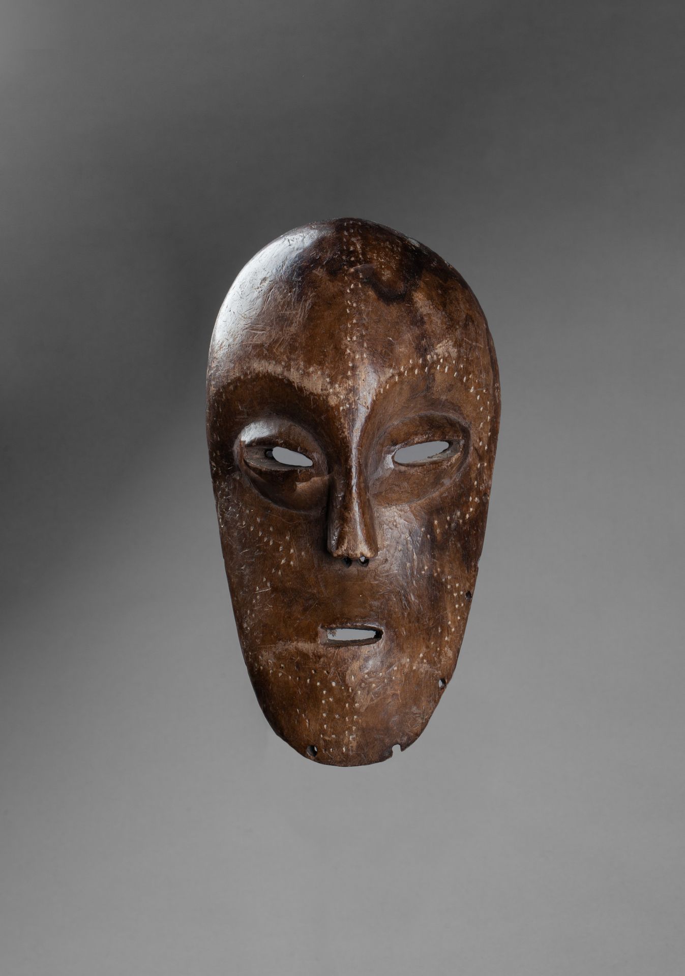 Masque de grade with an expressive face decorated with discreet incised patterns&hellip;