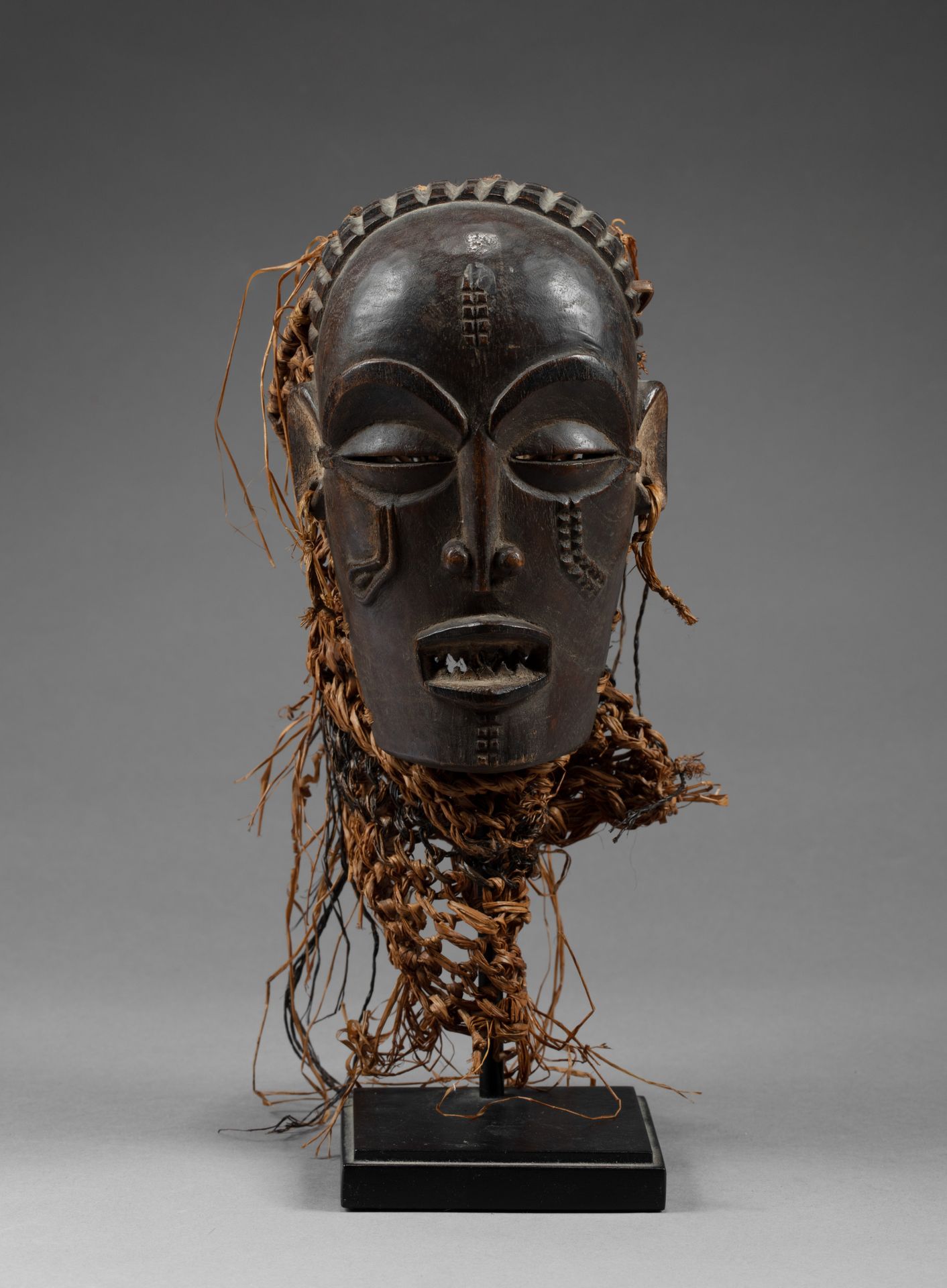 Masque de danse “Pwo” 它显示了一张表情紧张的女性面孔，脸颊和额头上有疤痕。

木头，古老的棕色铜锈，天然颜料，植物纤维，藤条，使用的痕迹。&hellip;