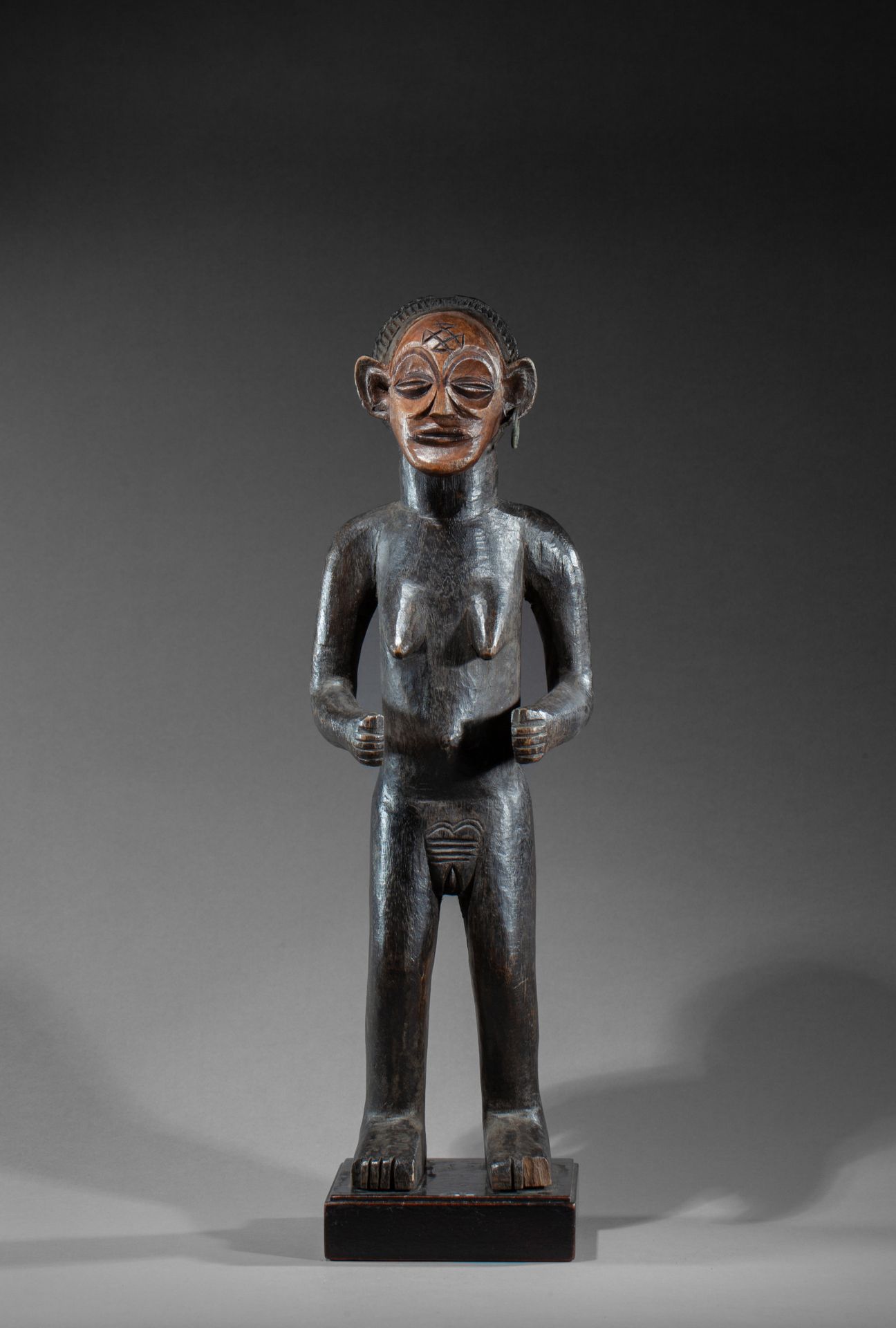 Statue féminine 显示她闭着眼睛裸体站立，表情坚定

木头，古老的蜂蜜和棕色的铜锈

Tchokwe, 刚果民主共和国, 20世纪

48厘米