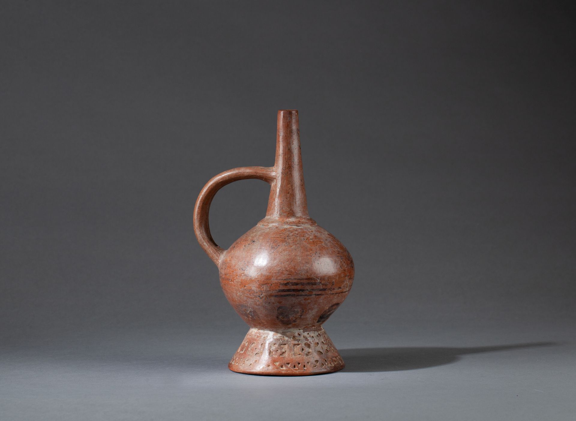 Vase 底部有一个长圆锥形的颈部和一个双柄，它的底部有一个雕刻的装饰。 

橙色陶器，棕色装饰。 

秘鲁兰巴耶克，公元1100-1400年。

 23 x &hellip;