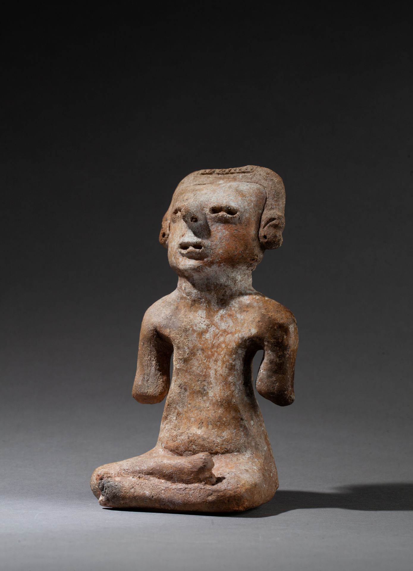 STATUETTE 显示了一个盘腿而坐的人物，他的脸很年轻，表情很紧张。

墨西哥米却肯州的沿海地区，公元前300-100年

16 x 8.5厘米