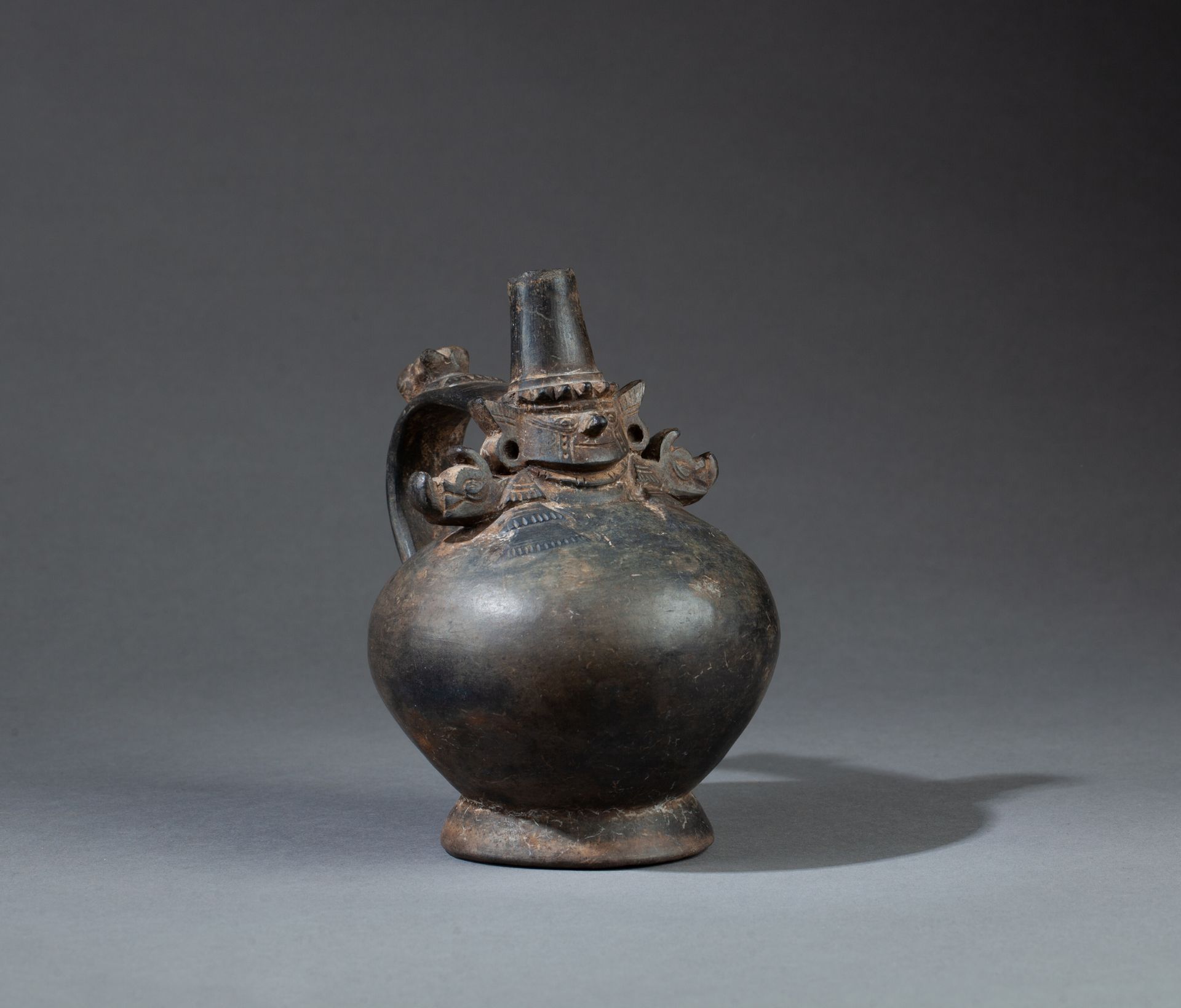 Vase à une anse 饰有两只鸟嘴对嘴。身体的顶部装饰着一个带皇冠的神像。

棕色粘土，颈部有两个非常小的缺口。

秘鲁兰巴耶克，公元1100-140&hellip;