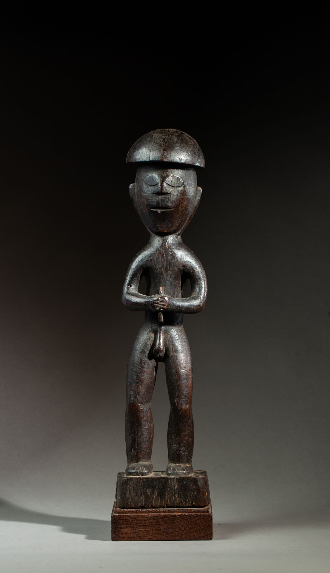 Statue masculine présentée nue debout sur un piédestal rectangulaire, il tient d&hellip;