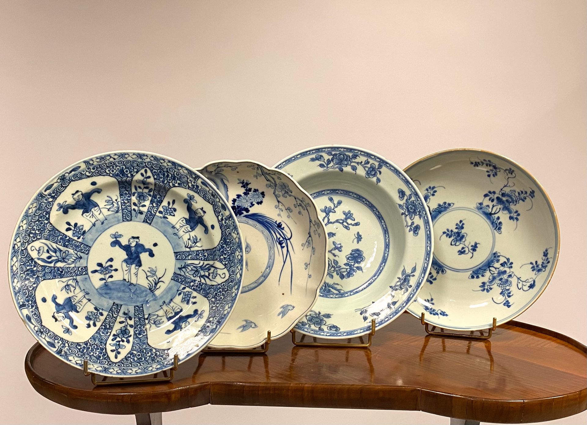 Null 中国，18和19世纪

一套四件白底蓝纹的瓷盘，包括

- 盘子有多棱边，上面有龙纹和梅花图案，背面装饰有长寿桃；直径：21, 5厘米

- 饰有枝头&hellip;