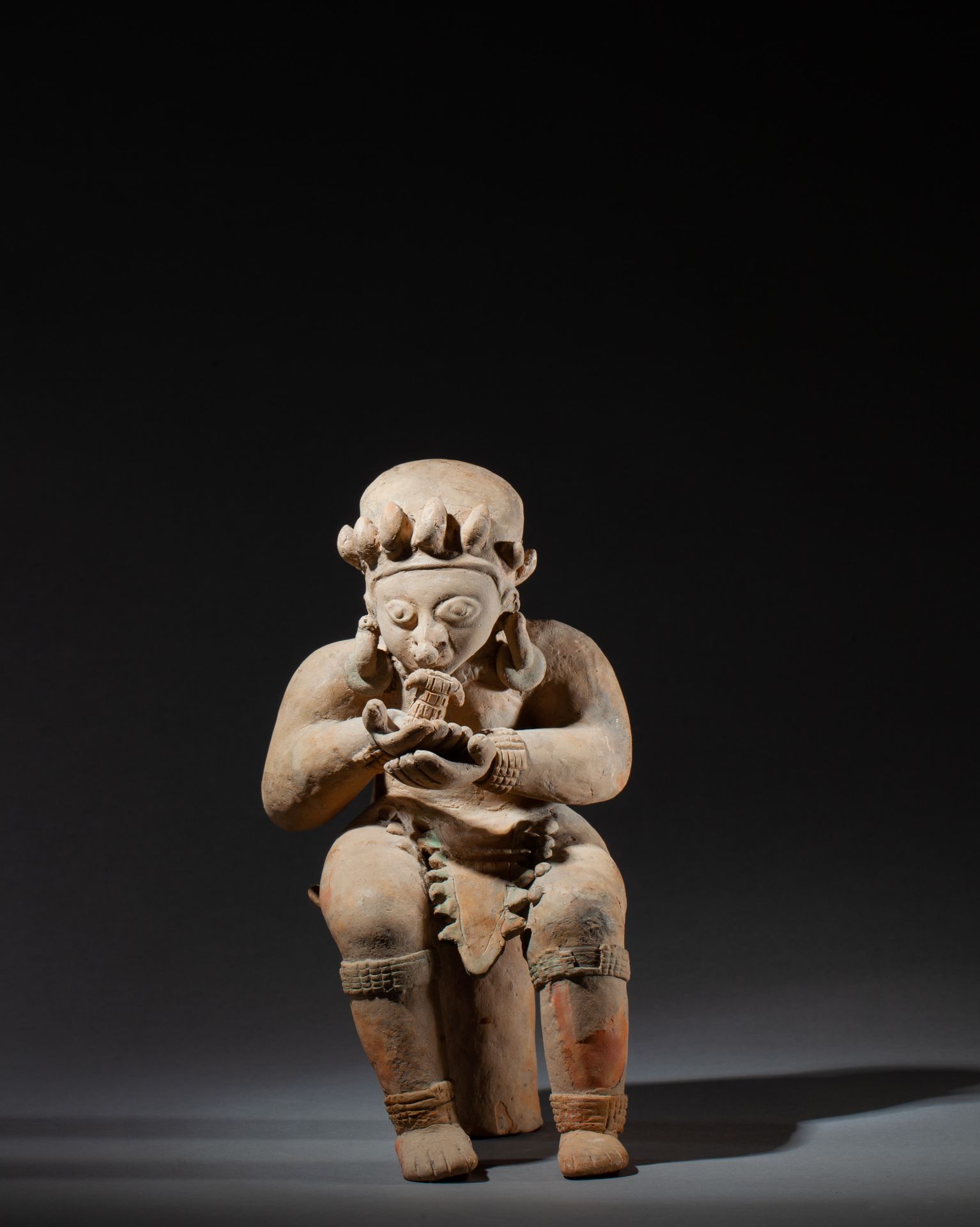 *Chamane seated on his throne, his oversized hands hold a figurine positioned in&hellip;